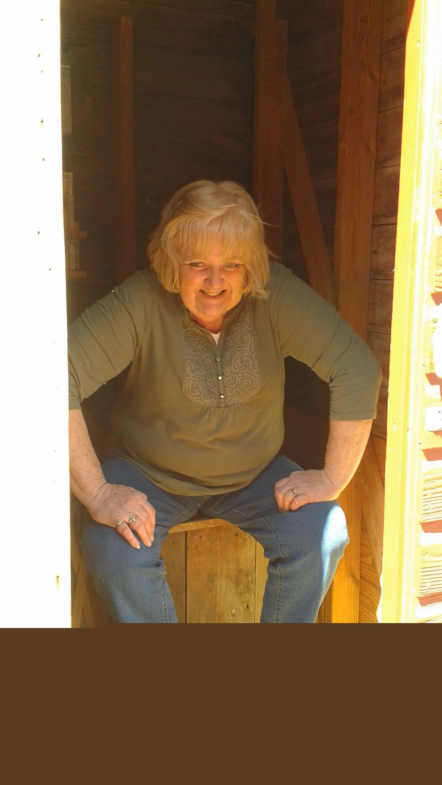 A woman sitting in a small shed