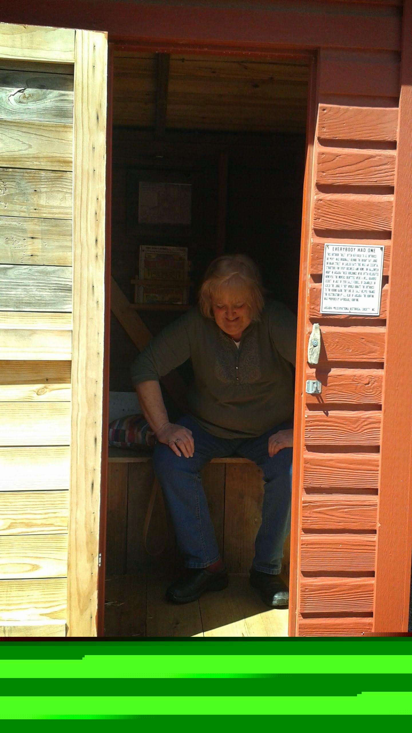 A woman sitting in a wooden shed