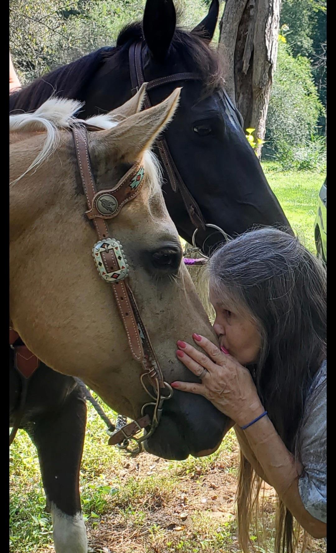 A woman kissing a horse