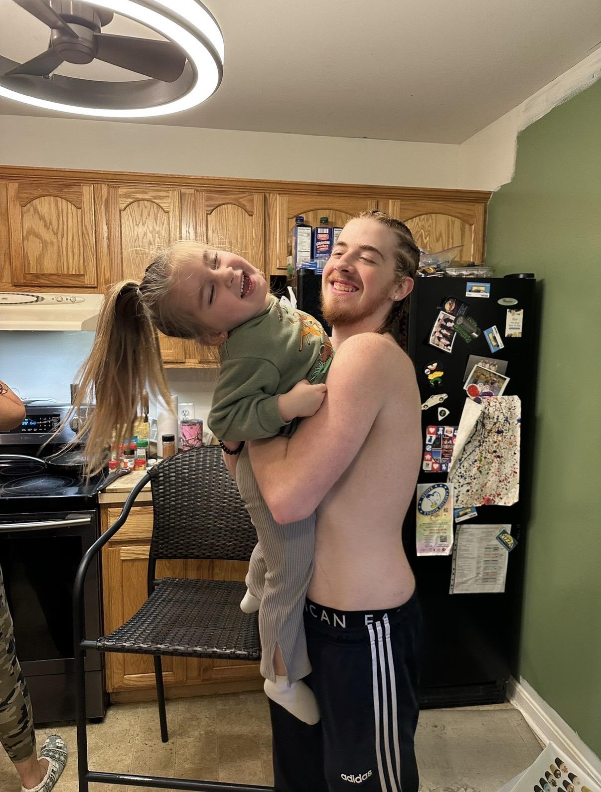 A man holding a child in a kitchen