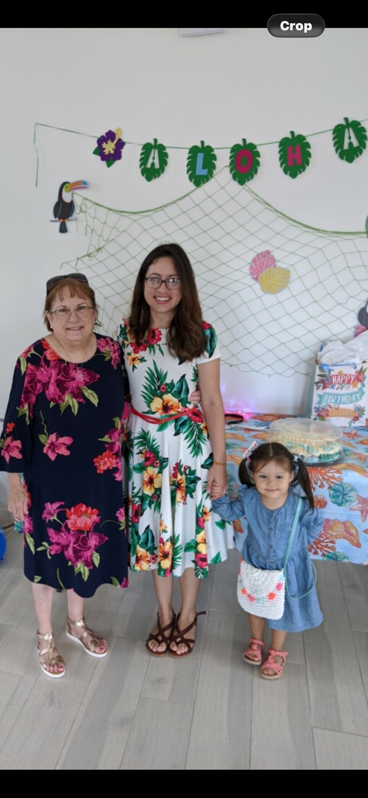 A group of women standing in front of a table with a birthday cake