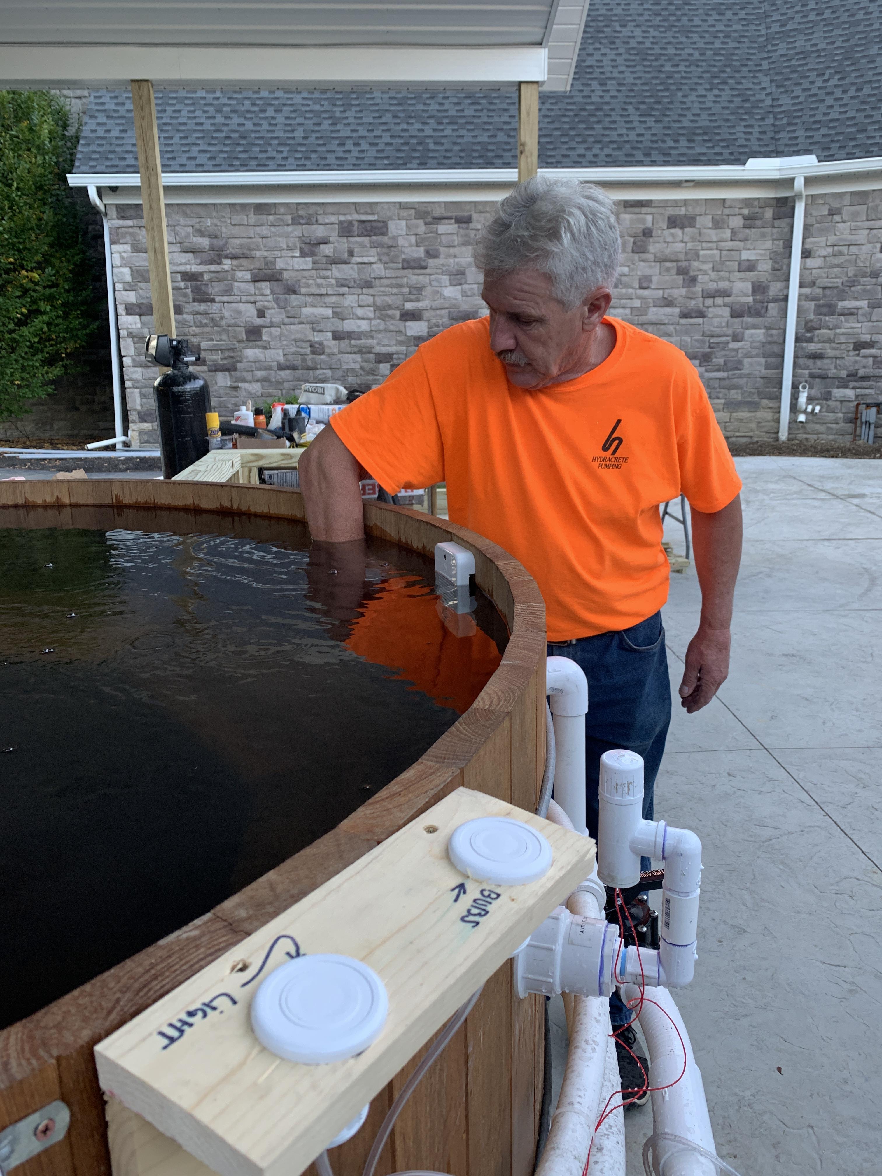 A man standing next to a wooden barrel