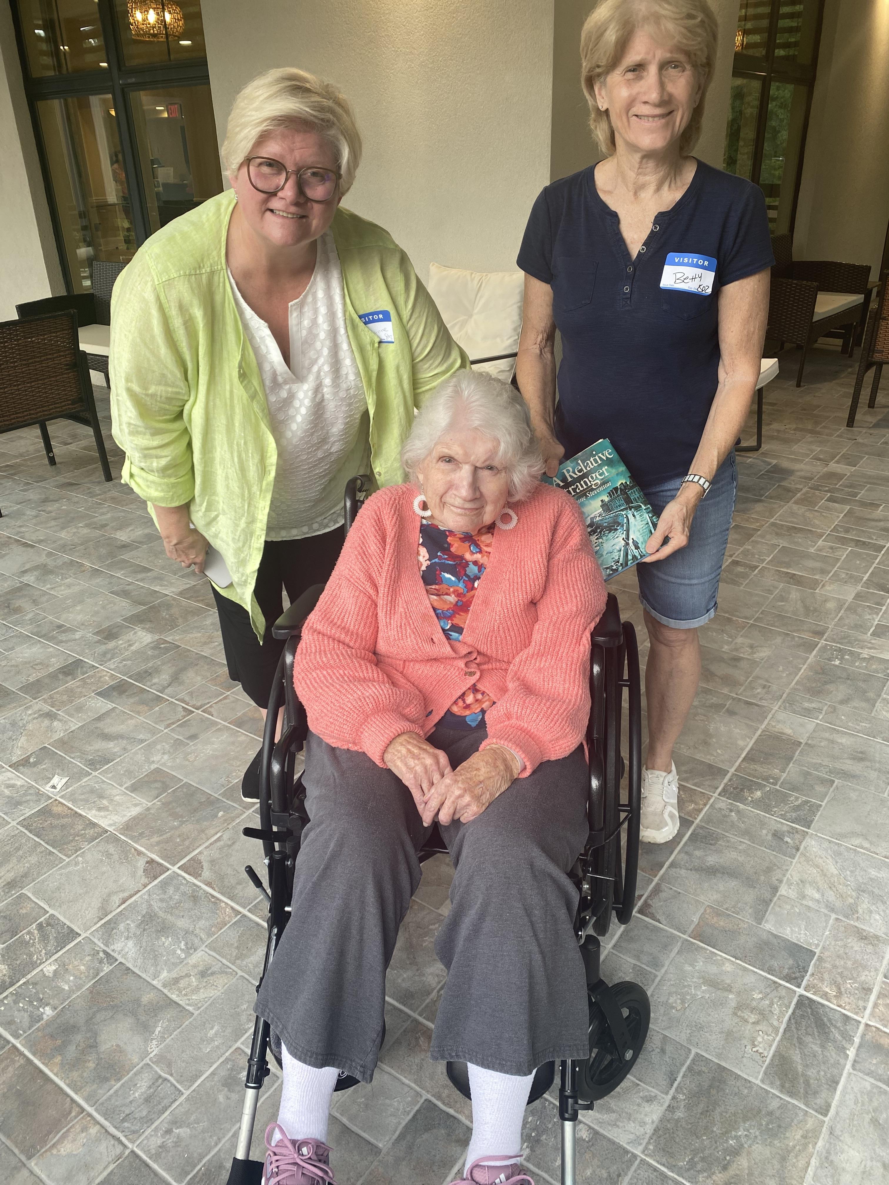 A group of women standing next to a woman in a wheelchair