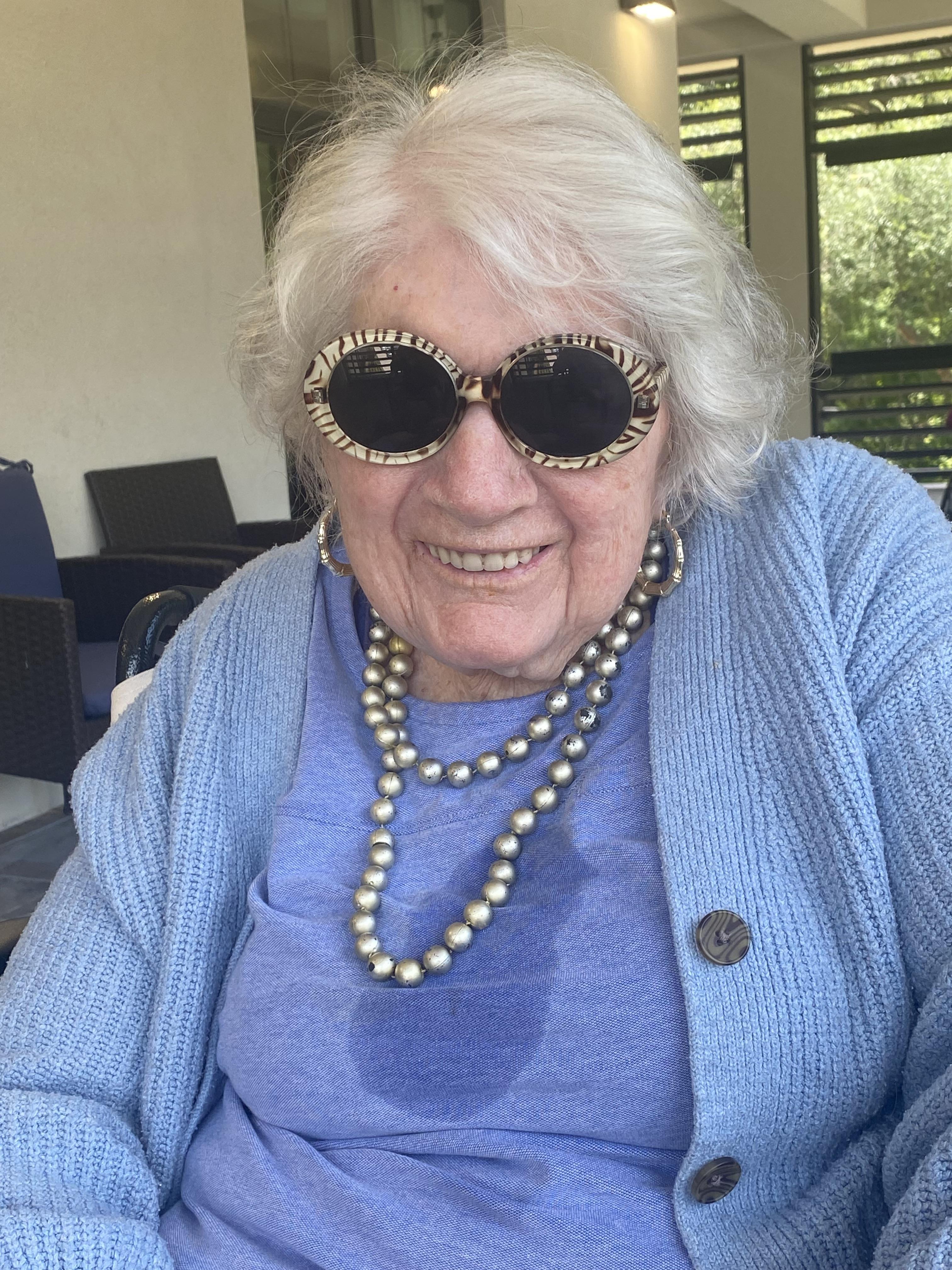 A woman wearing sunglasses and a blue sweater