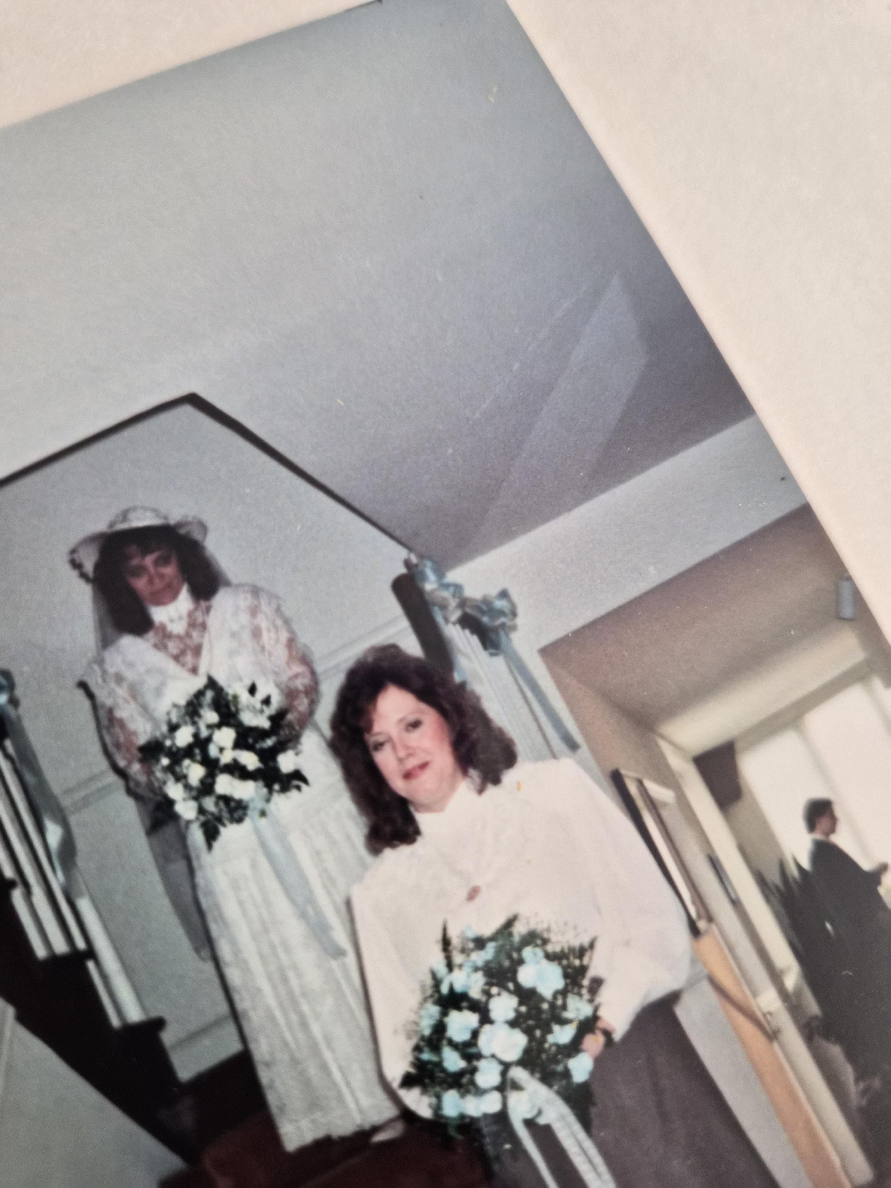 A woman in white dress holding flowers