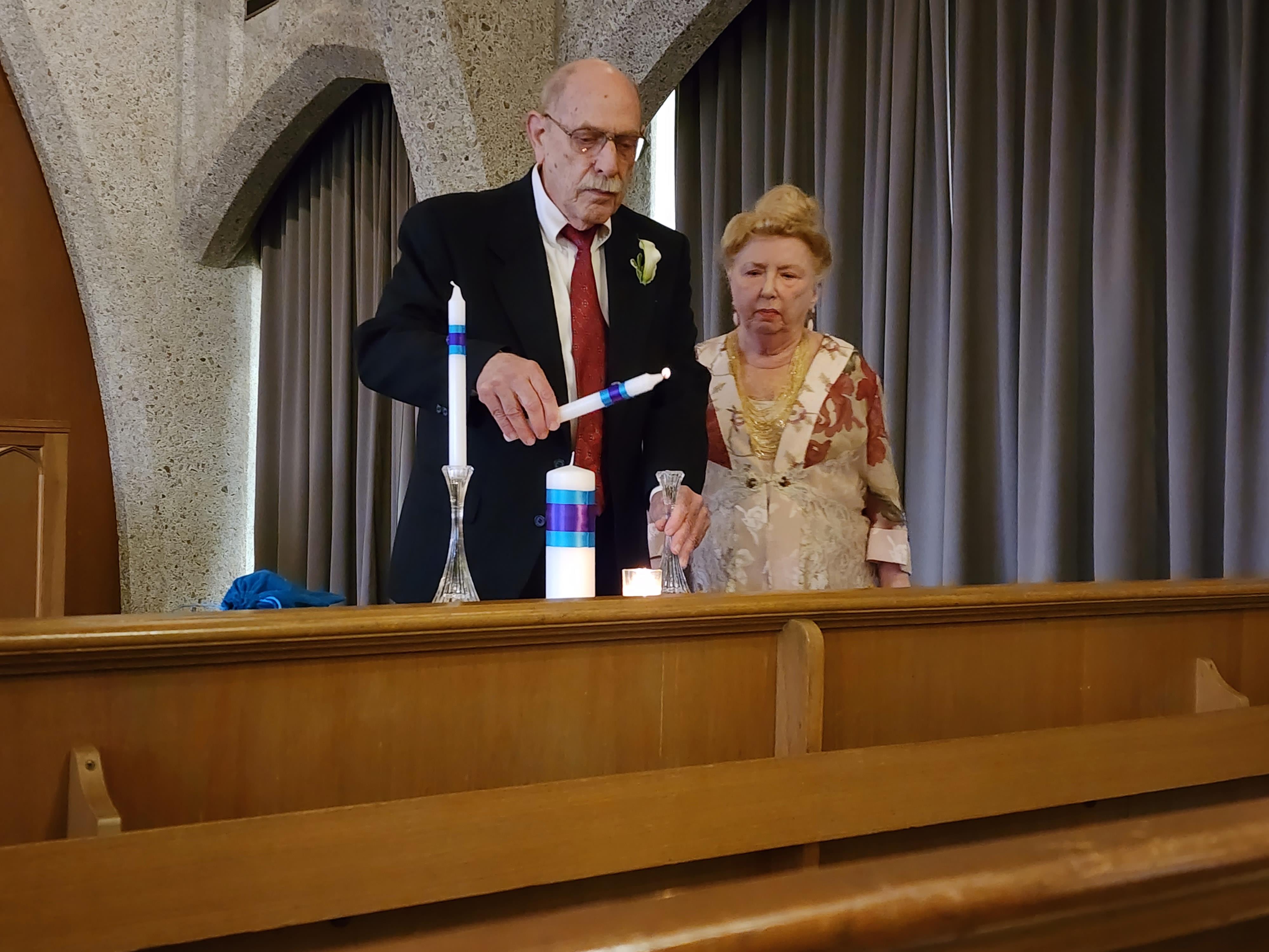 A man and woman standing in front of a pew