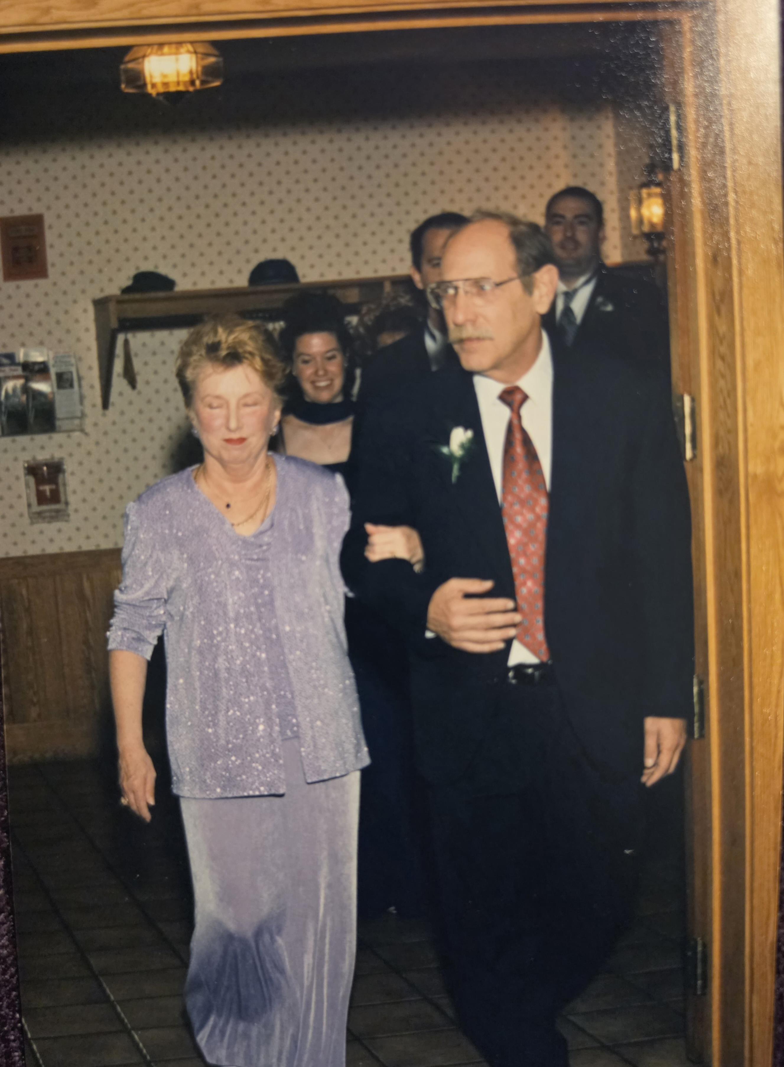 A man and woman walking in a room