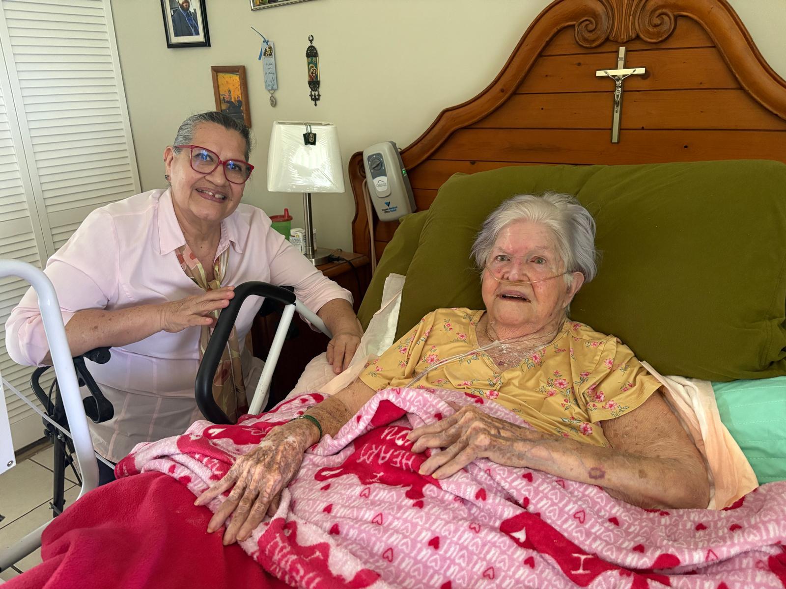 A woman in a hospital bed with a nurse