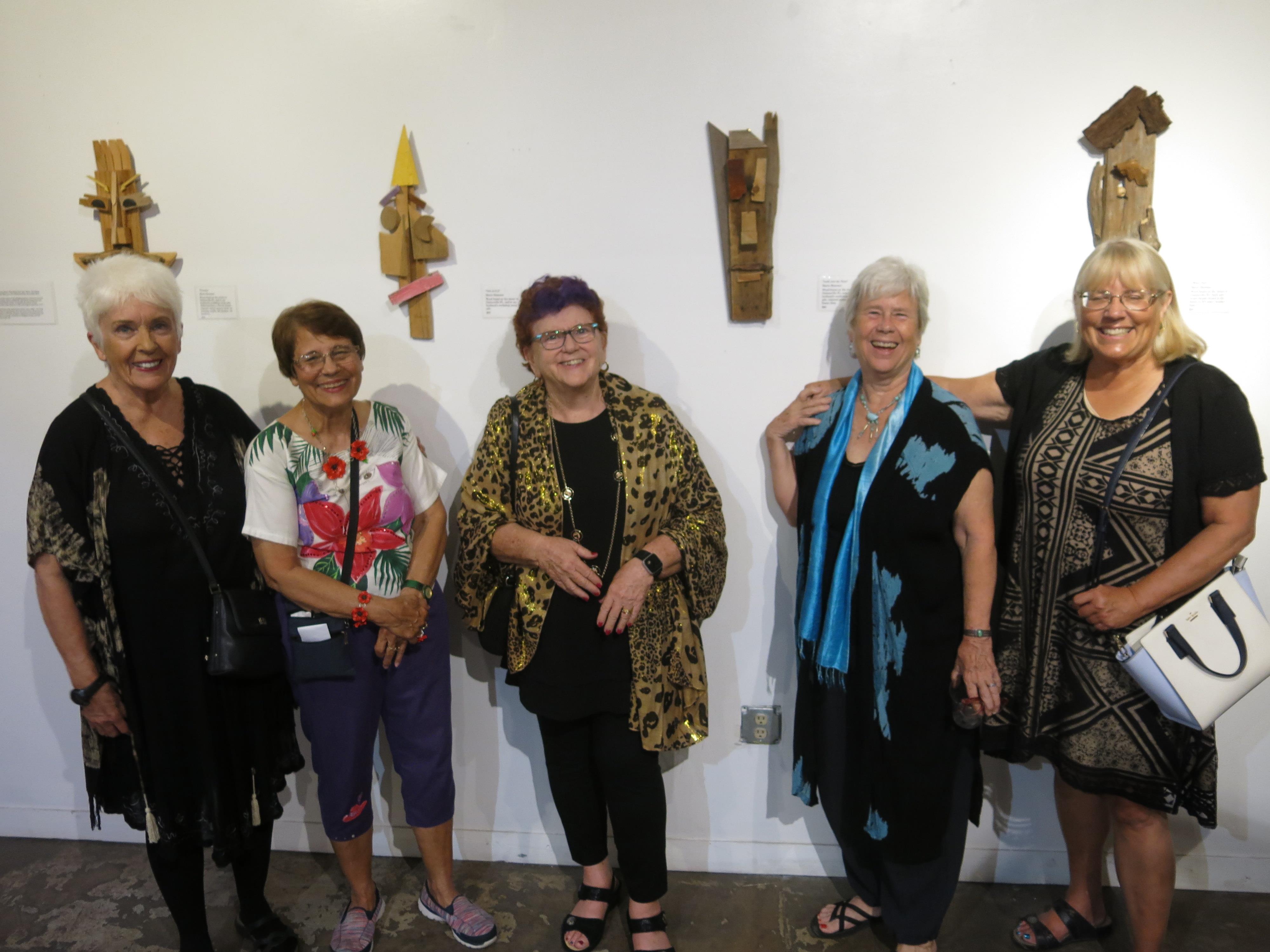 A group of women standing in front of a white wall