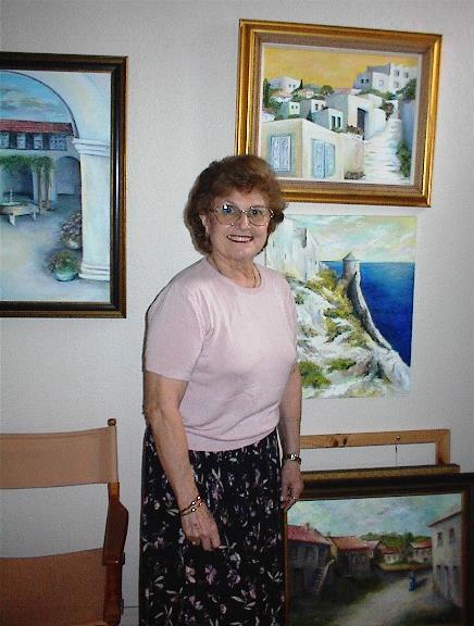A woman standing in front of a wall with paintings