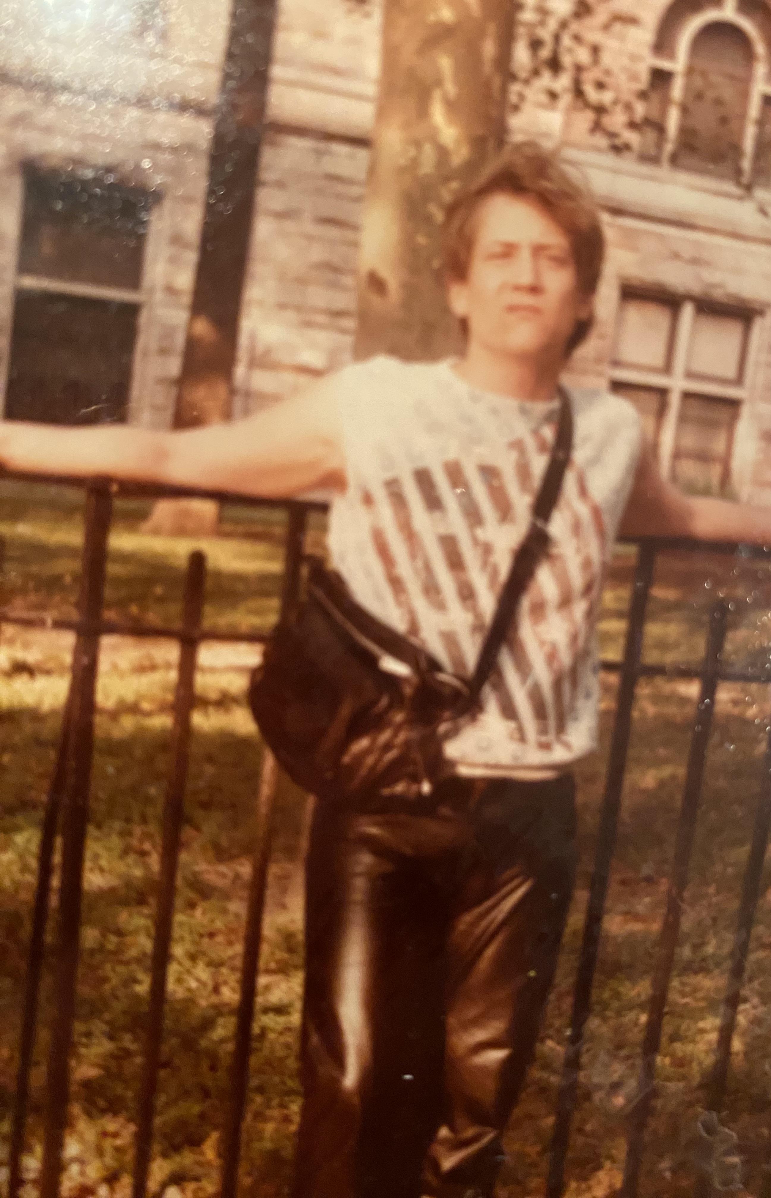 A man leaning on a fence