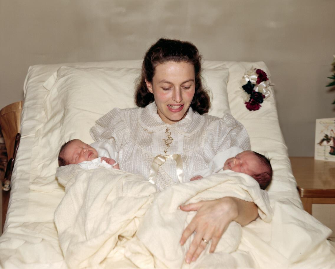 A woman holding two babies