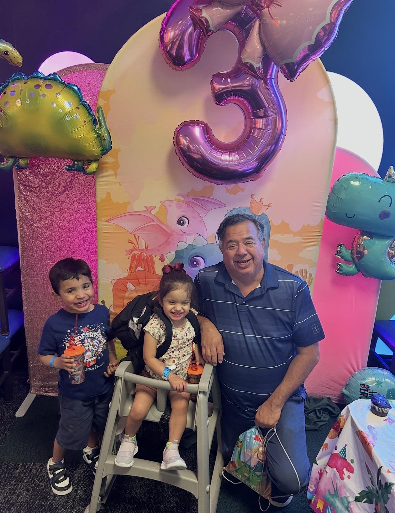 A man and two kids posing for a photo