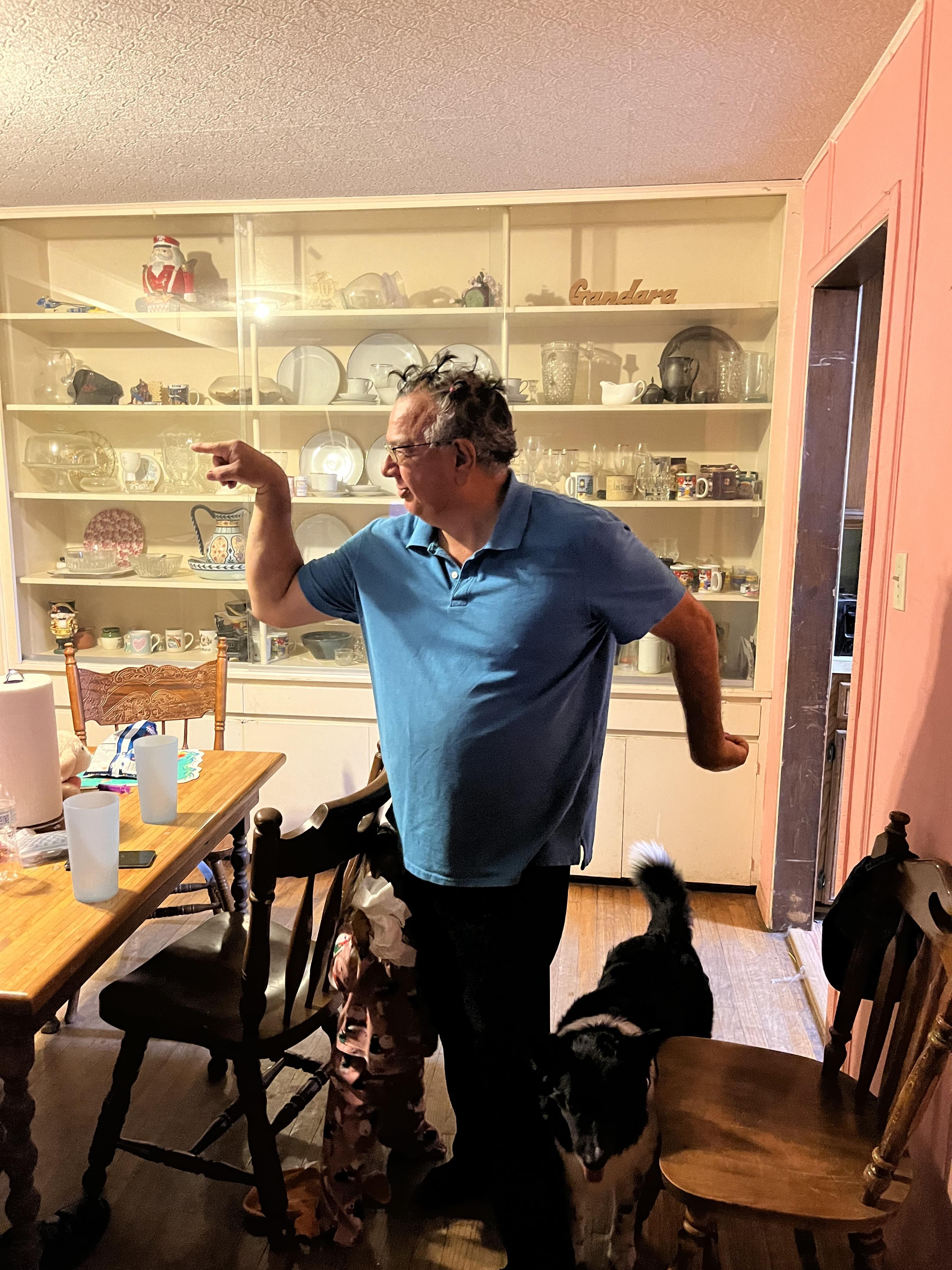 A man standing in a kitchen with a dog
