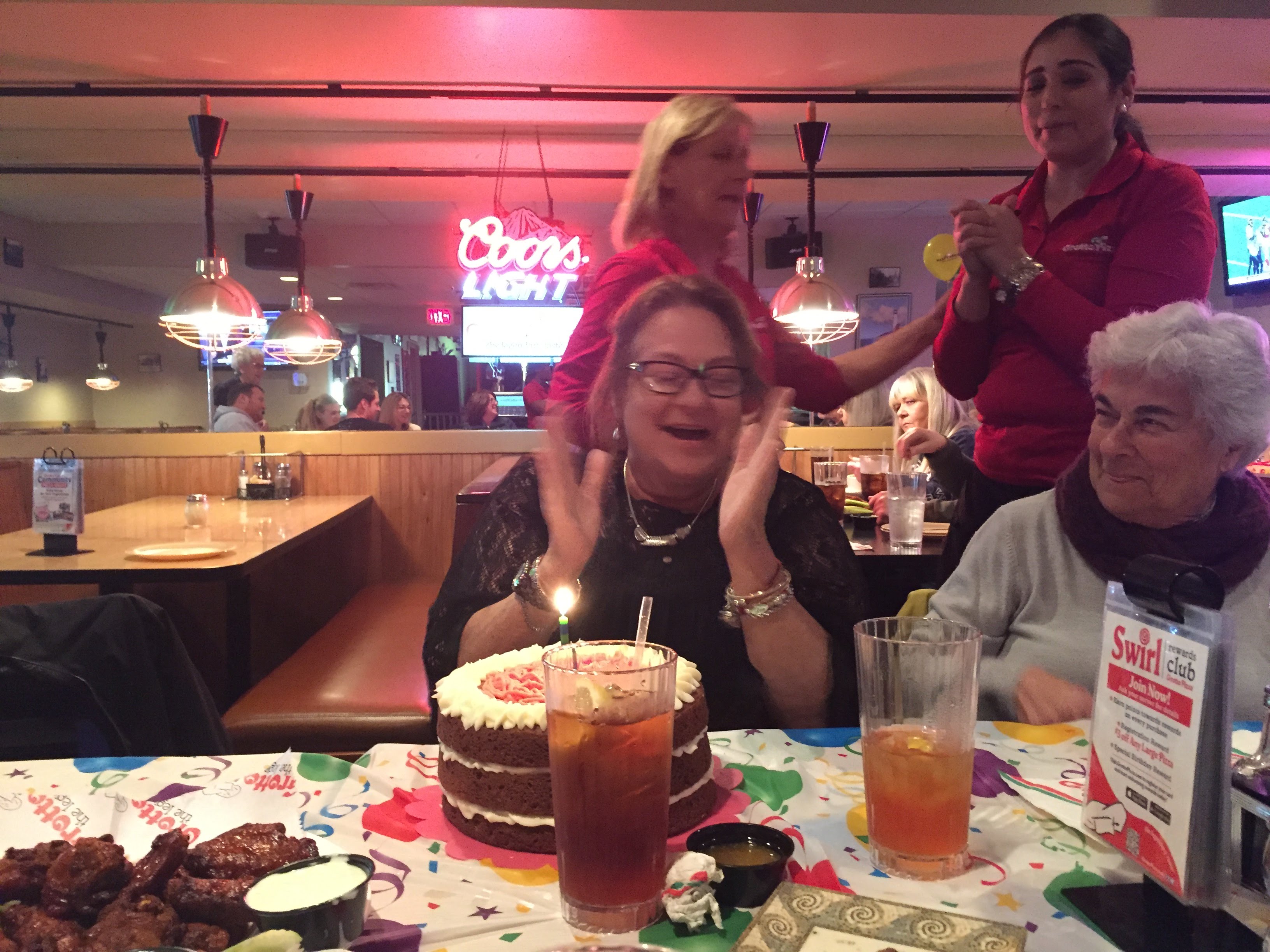 A group of people sitting at a table with a cake