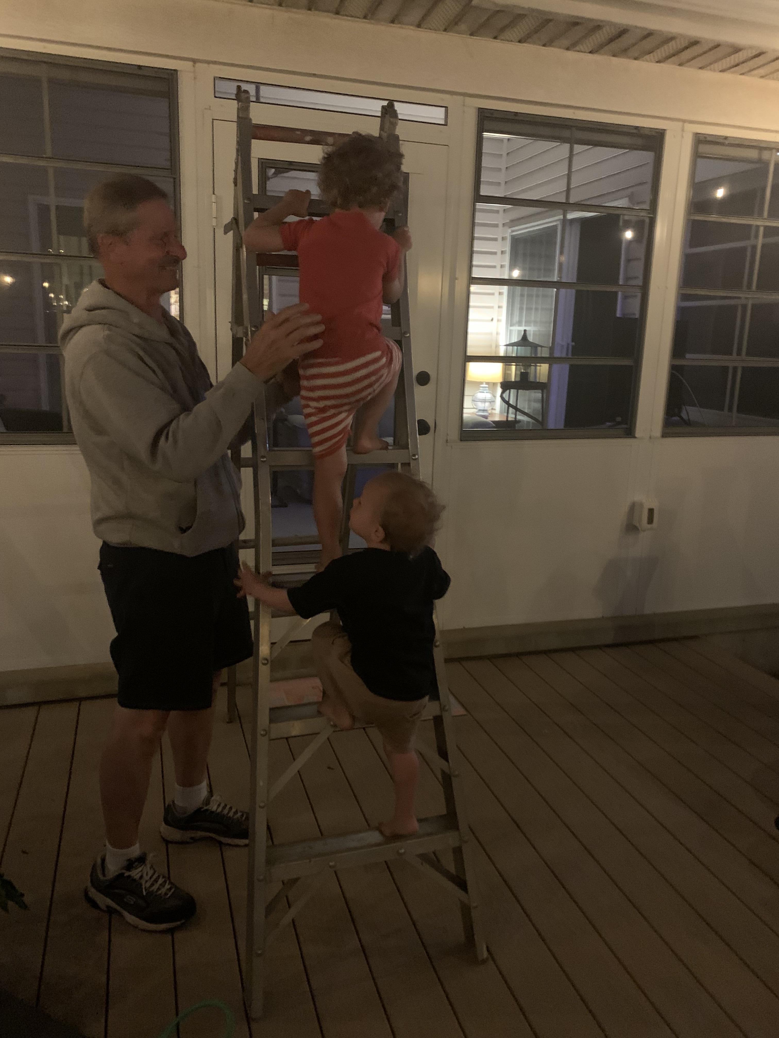 A man helping children climb a ladder