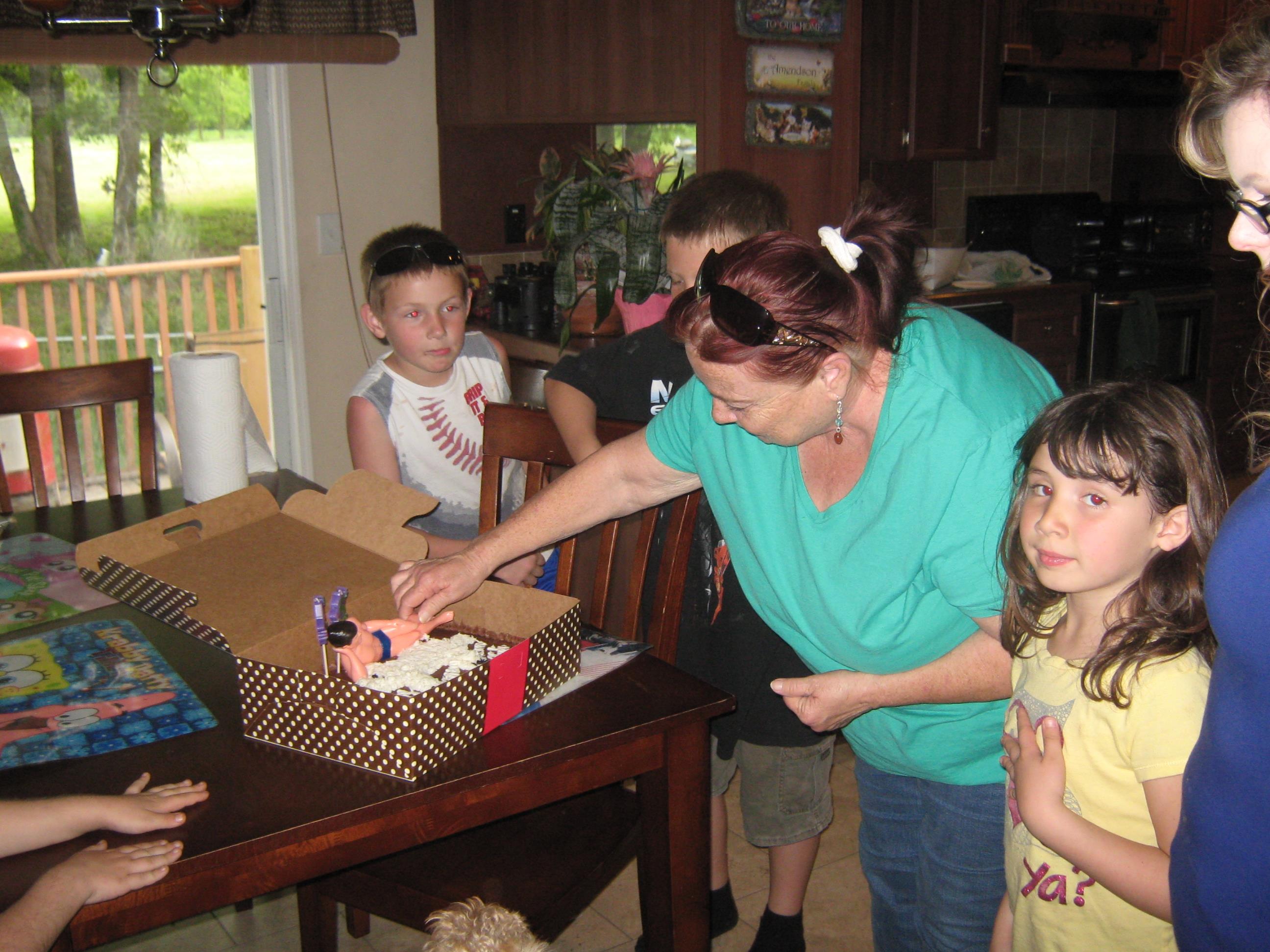 A woman opening a birthday cake