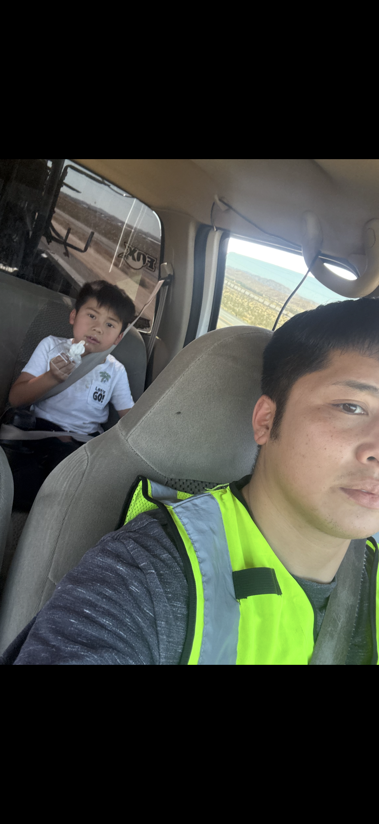A selfie of a boy and a boy in a car