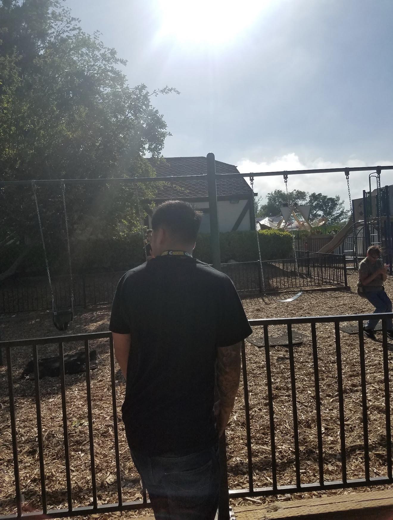 A man standing in front of a fence