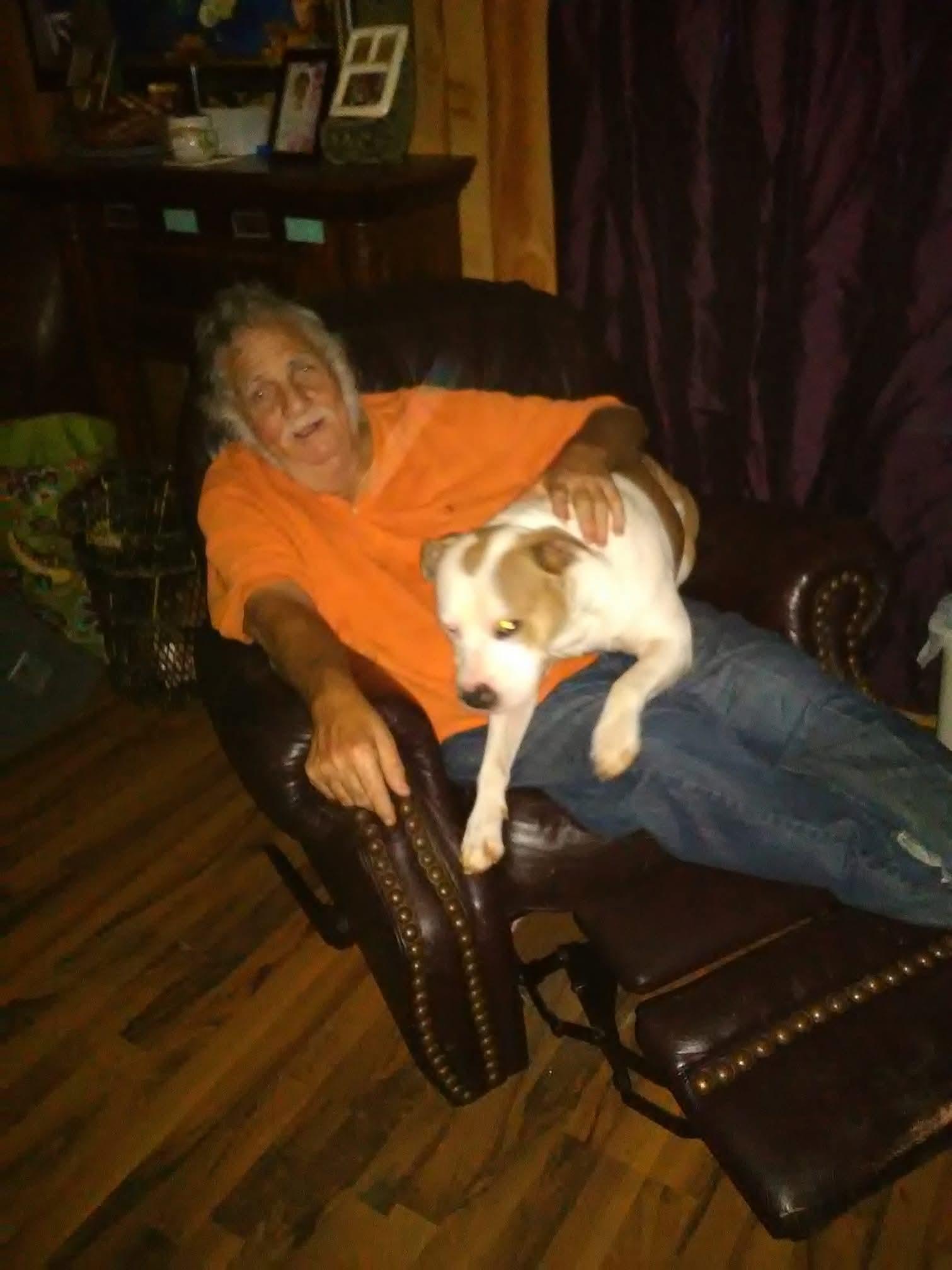 A person sitting in a chair with a dog