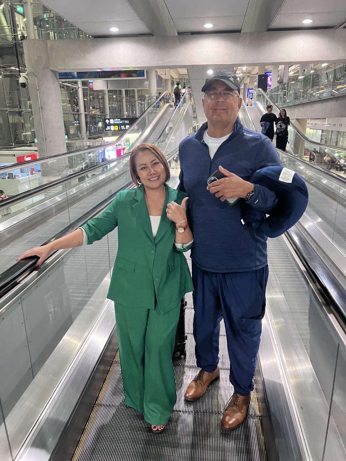A man and woman standing on an escalator