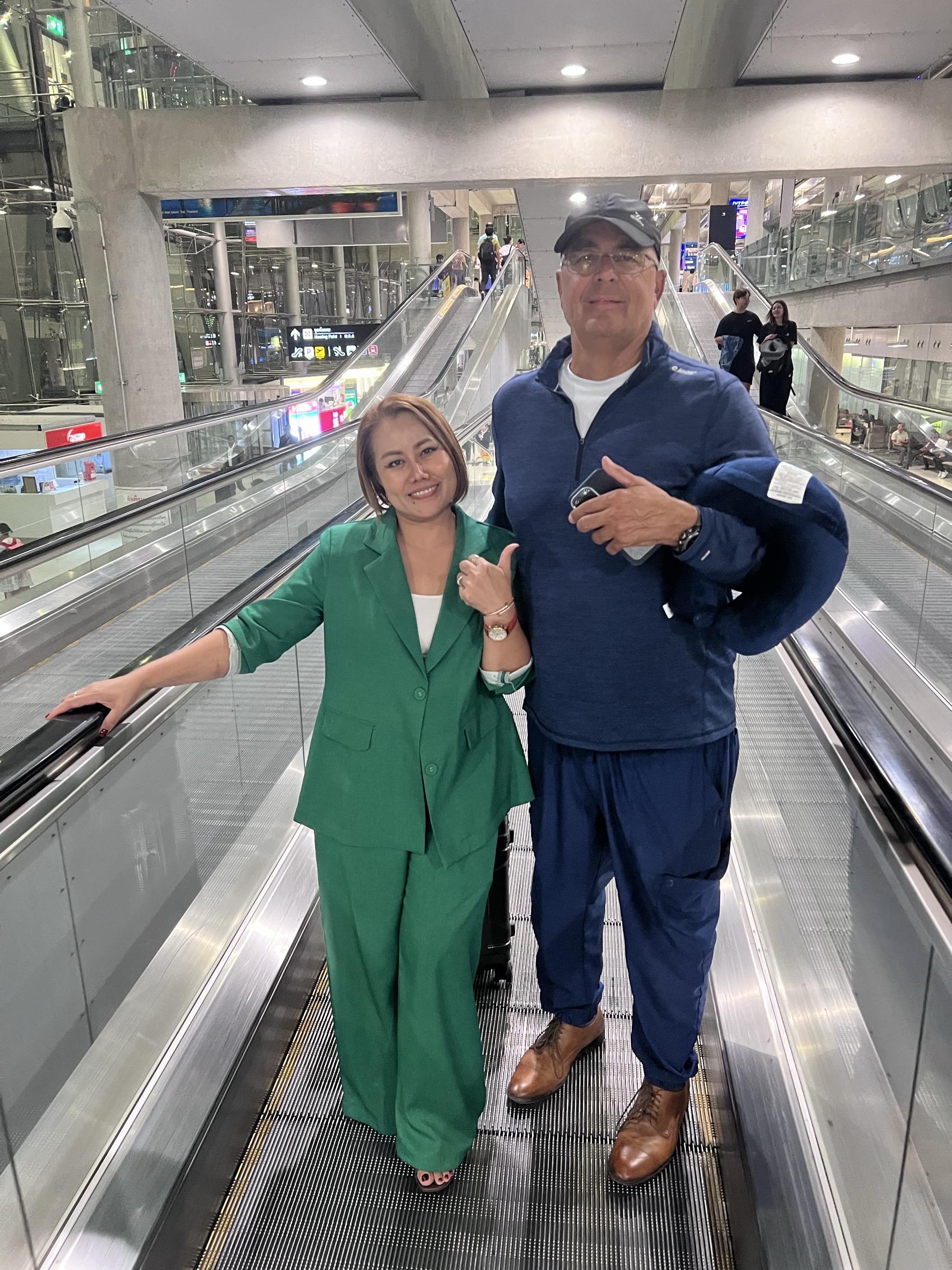 A man and woman standing on an escalator