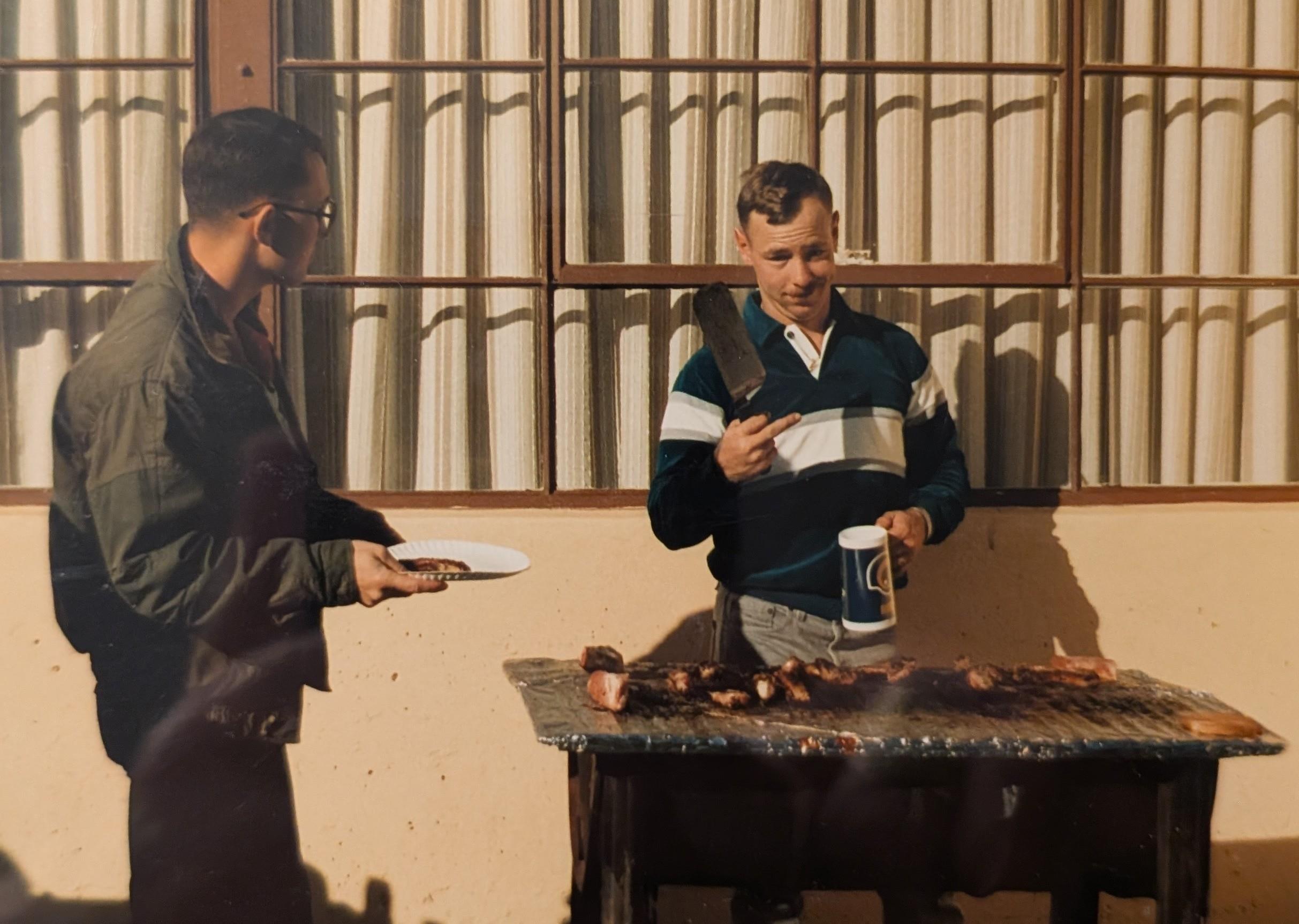 A man standing next to a man holding a plate
