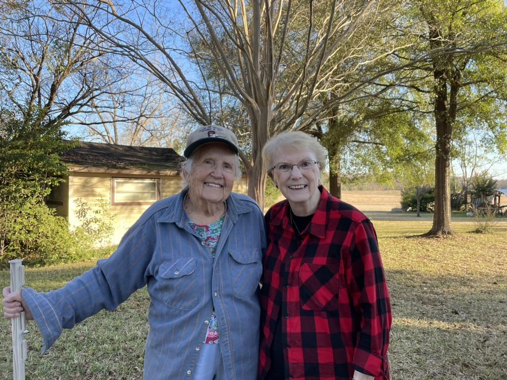 Two women standing together outside