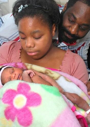 A man and woman holding a baby