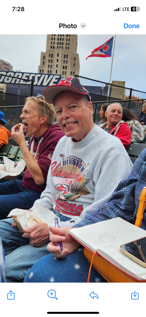 A group of people sitting in bleachers eating food