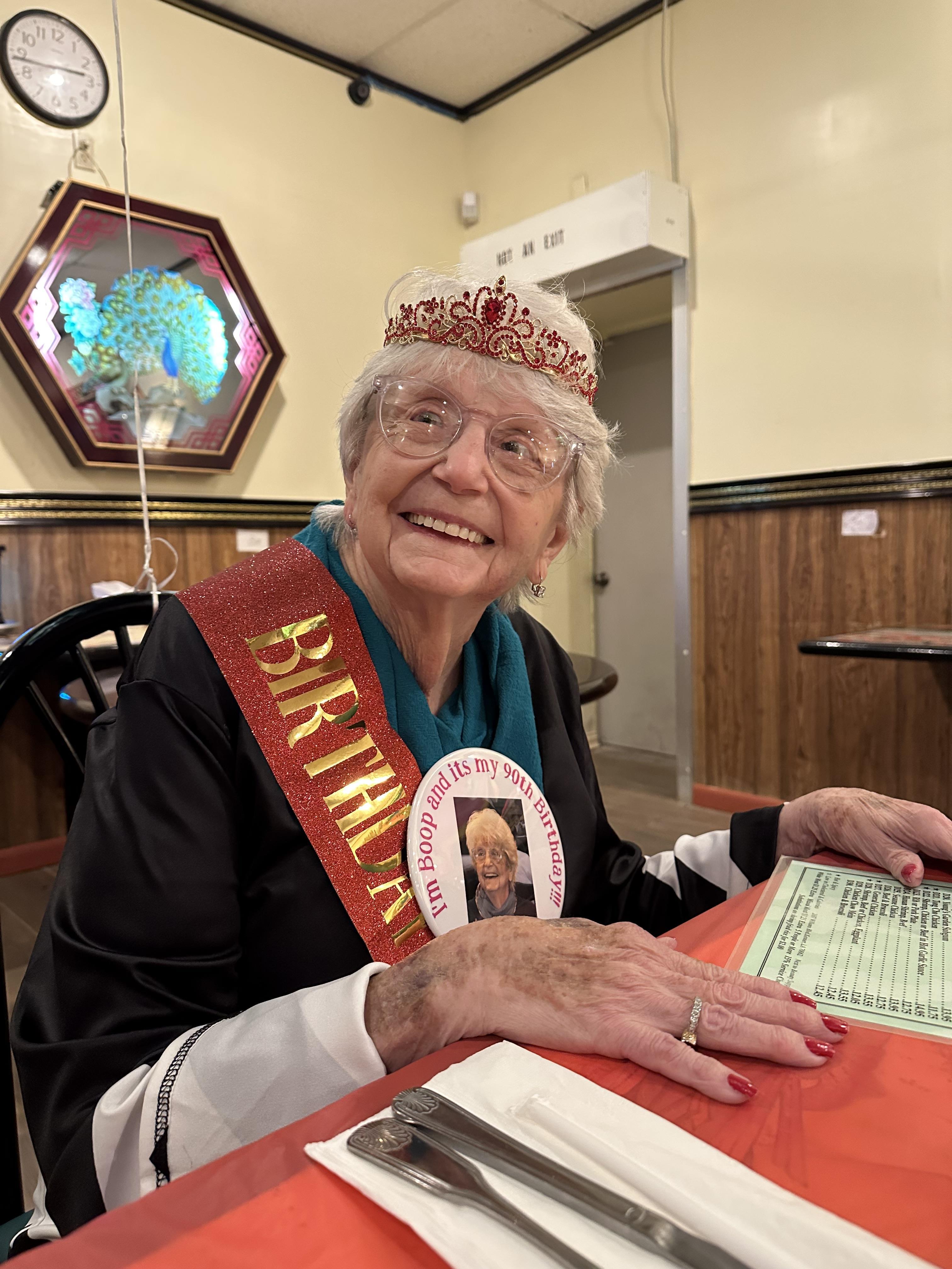 A woman wearing a crown and a sash