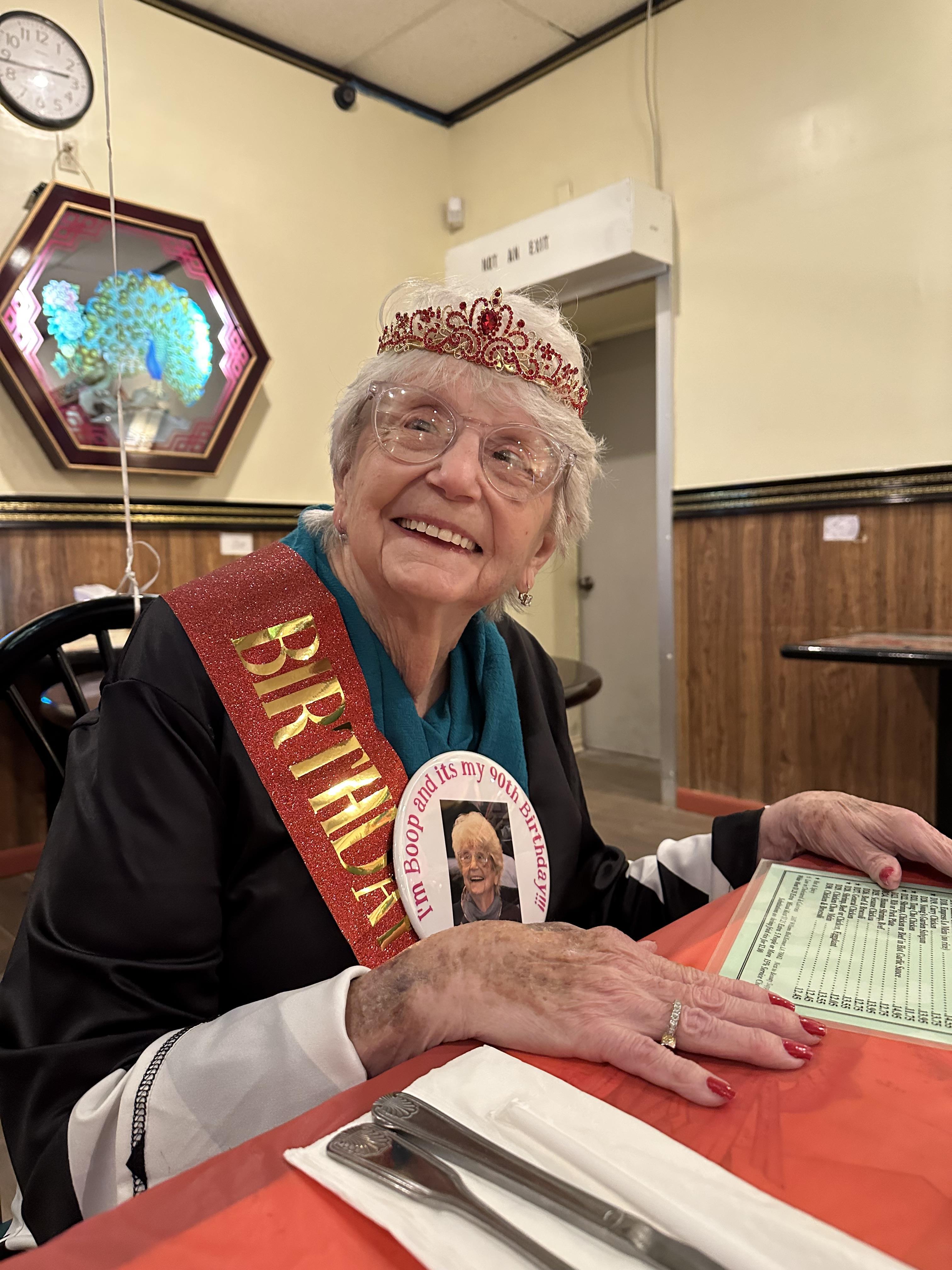 A woman wearing a crown and a sash