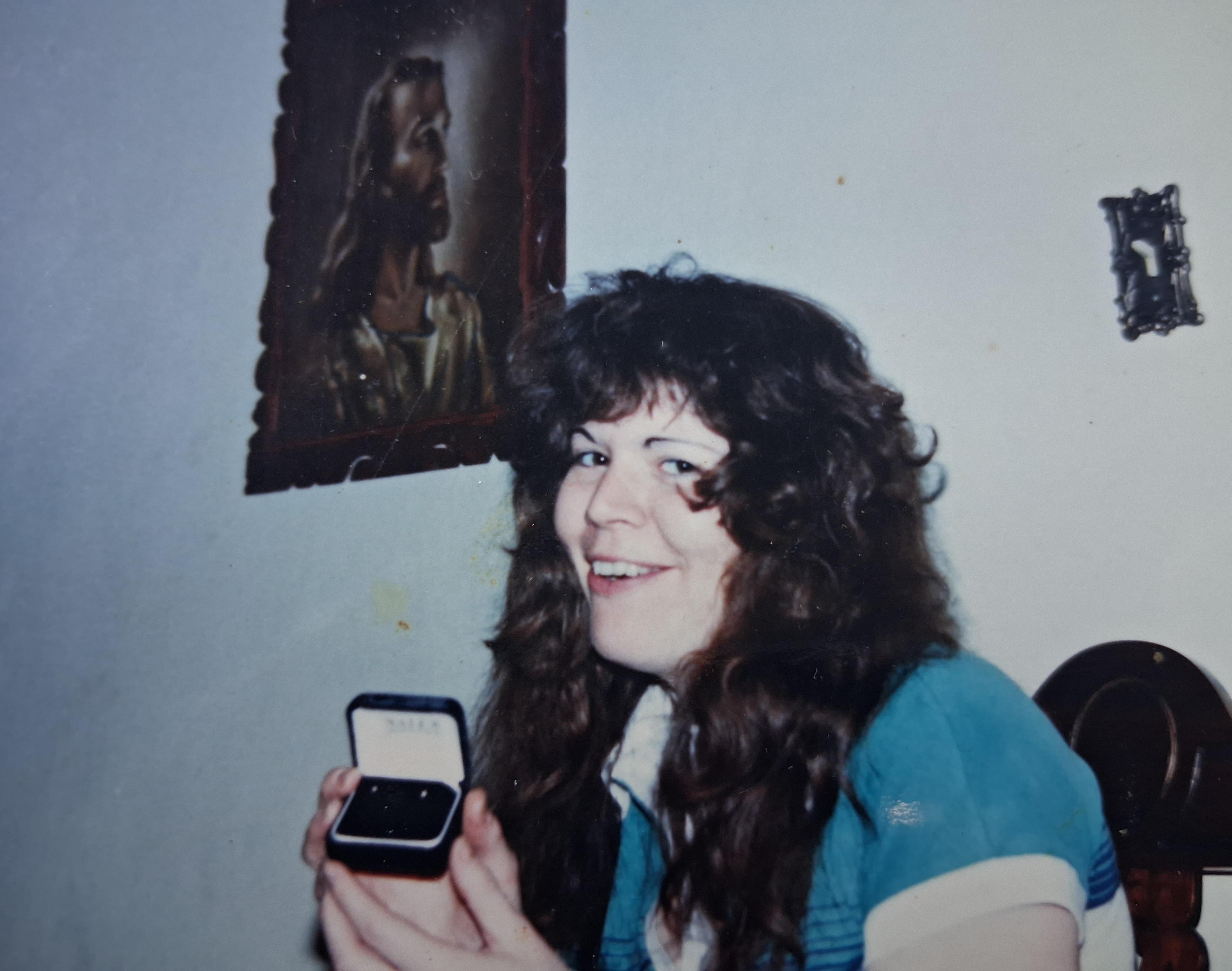 A woman holding a box with a ring in her hand