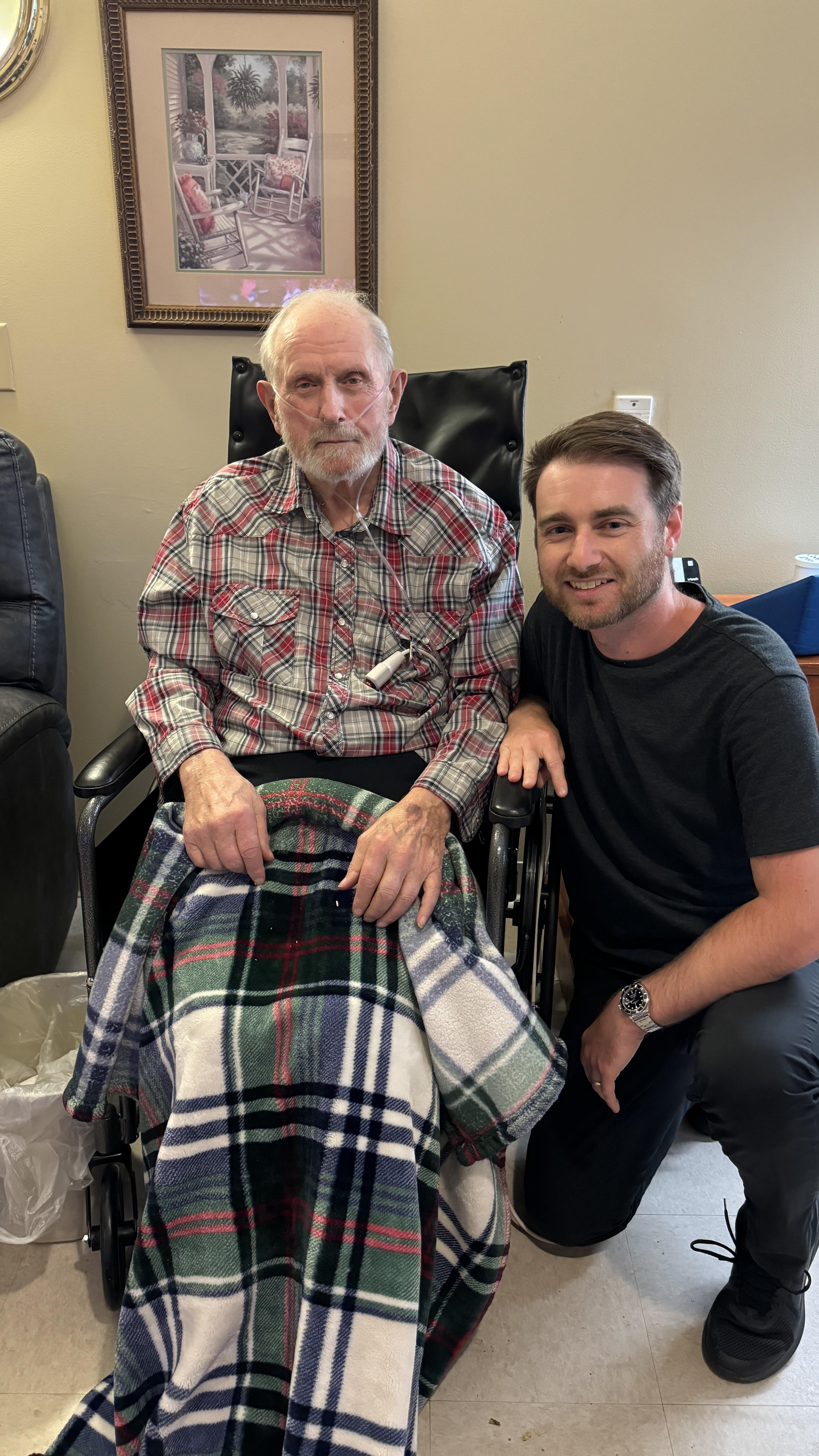 A man sitting in a wheelchair next to an old man