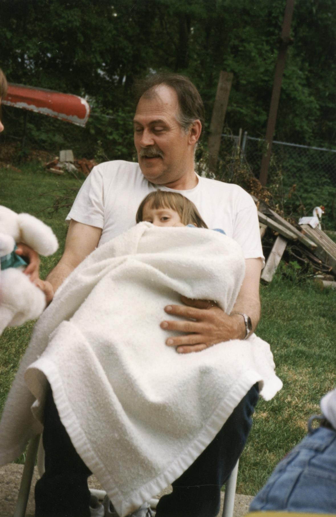 A man holding a child wrapped in a blanket