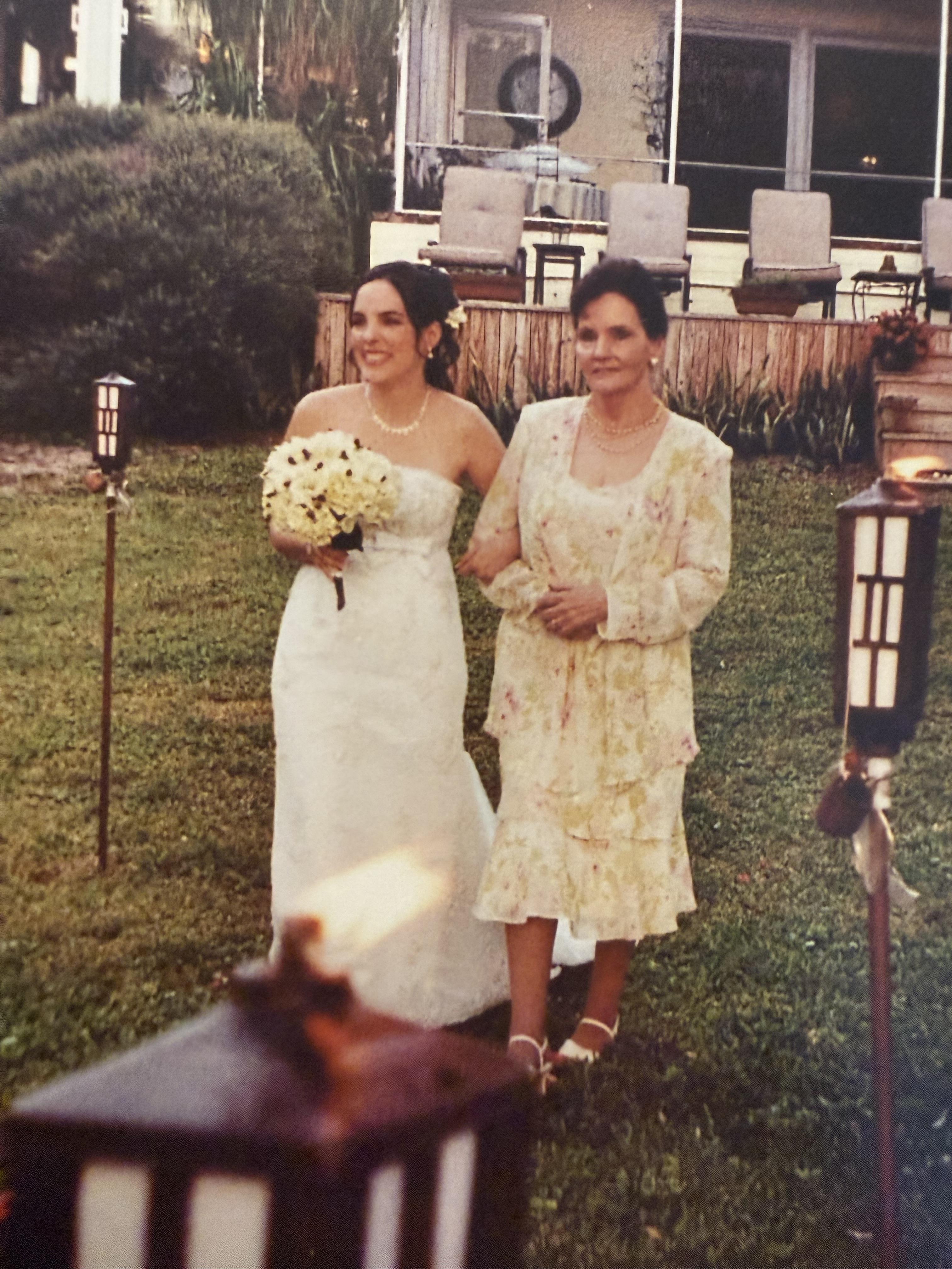 A woman in a white dress walking with another woman in a white dress