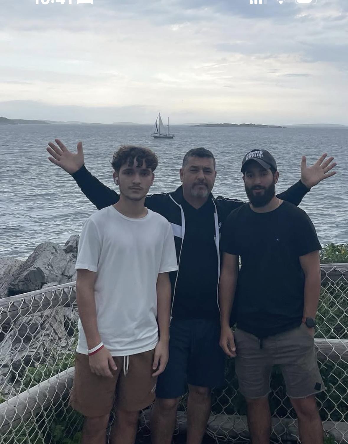 A group of men standing in front of a body of water