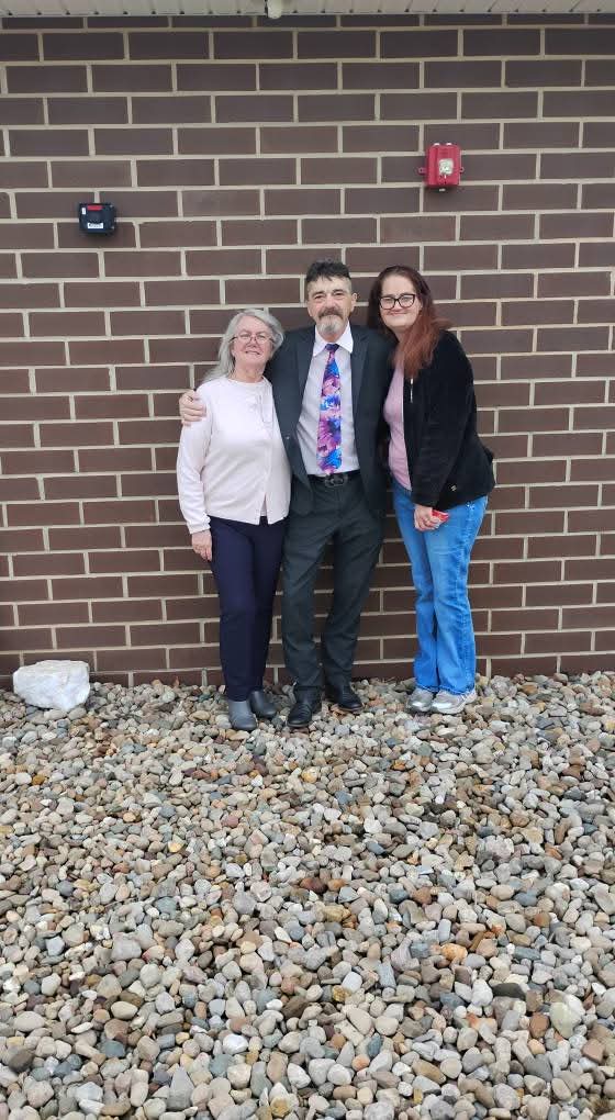 A group of people standing in front of a brick wall