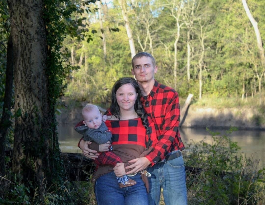 A man and woman holding a baby