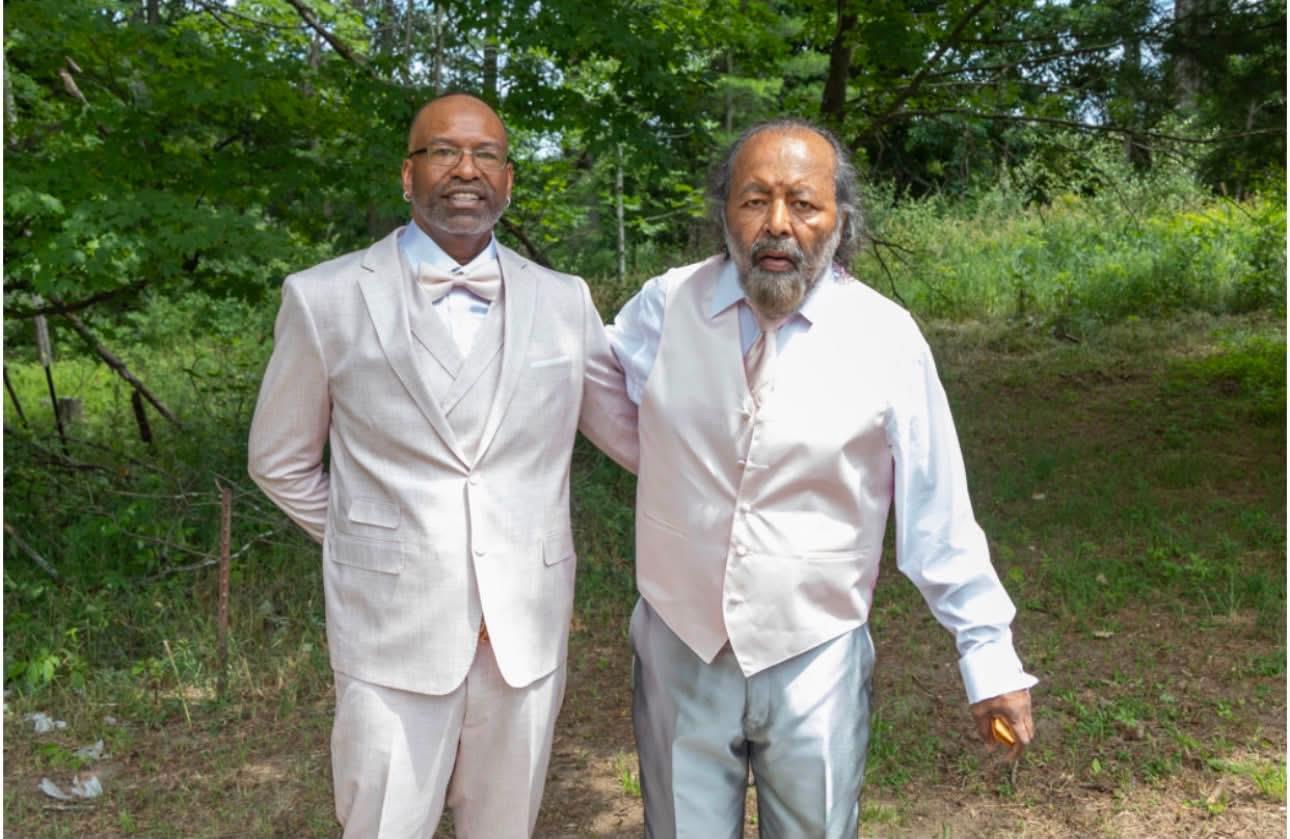 Two men in suits standing in a forest