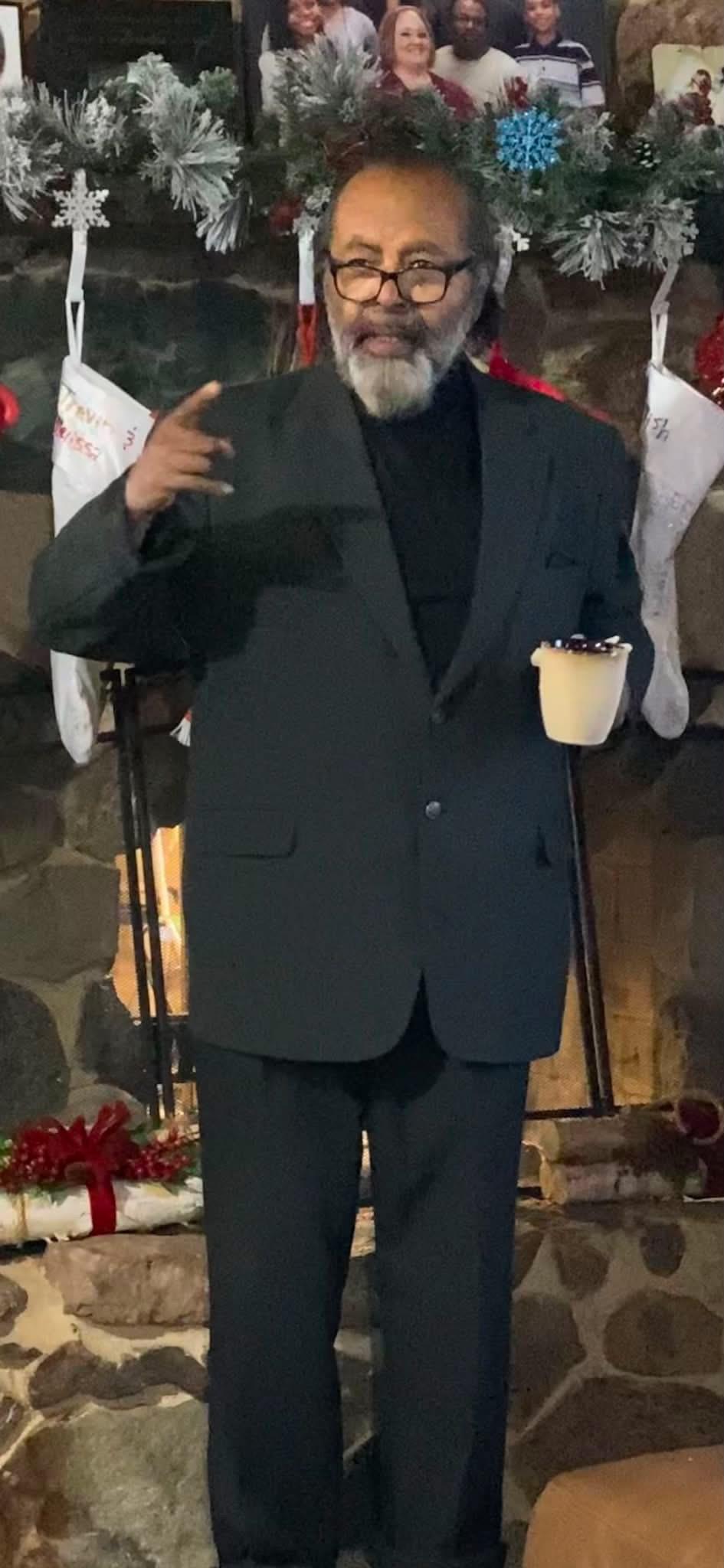 A man in a suit holding a cup