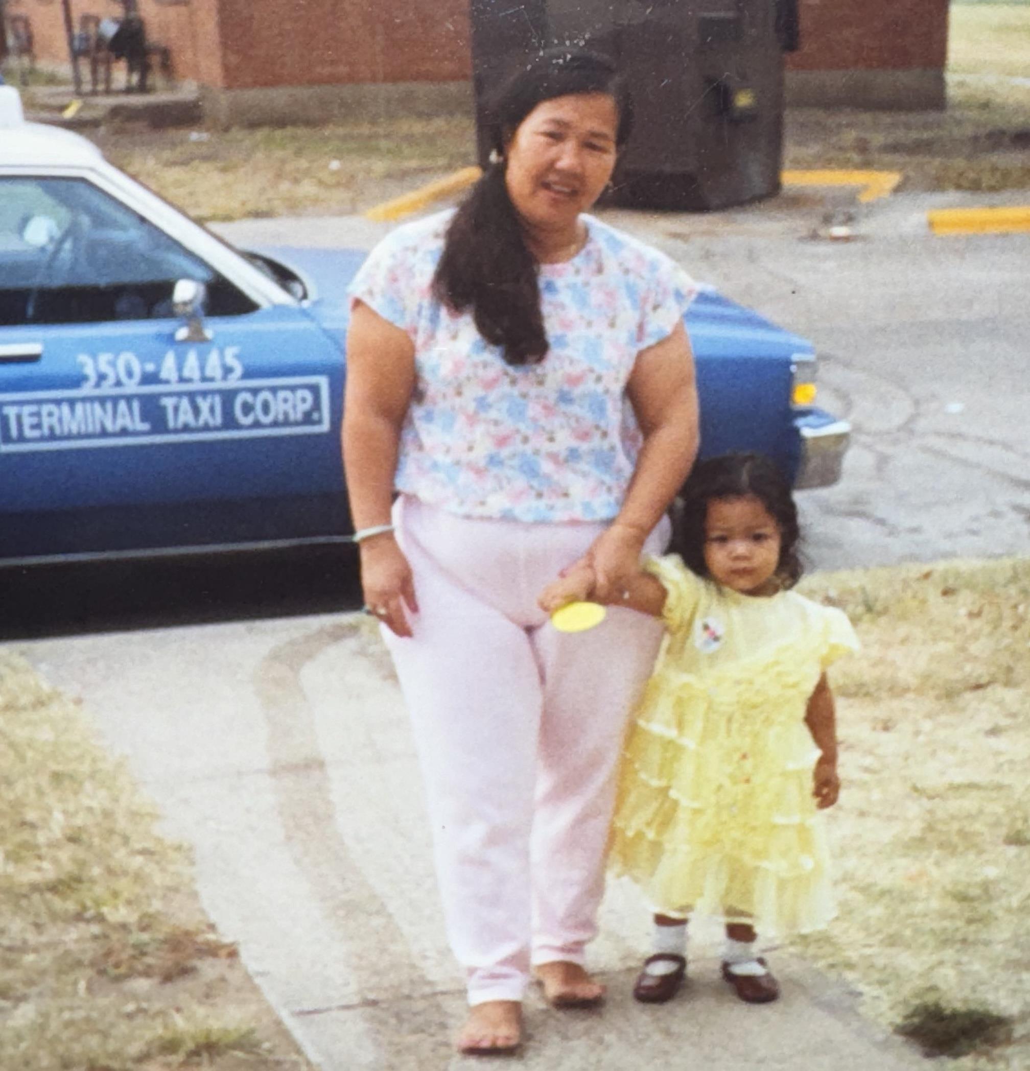 A woman and a child walking on a sidewalk