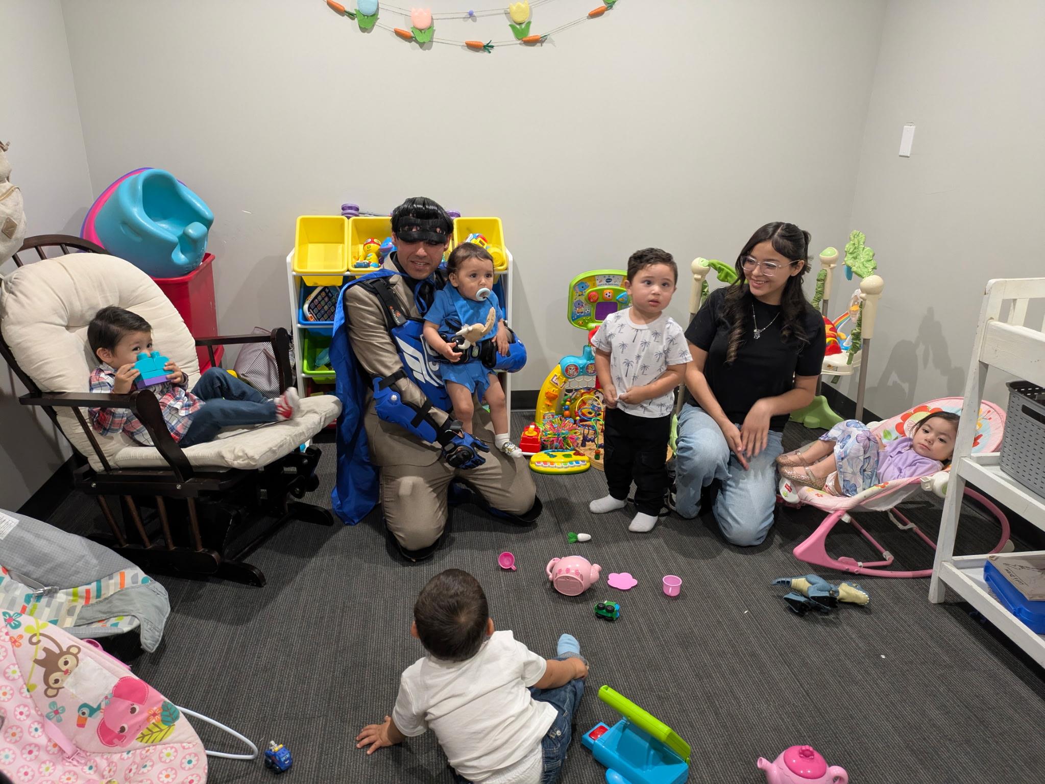 A group of people sitting on the floor with toys