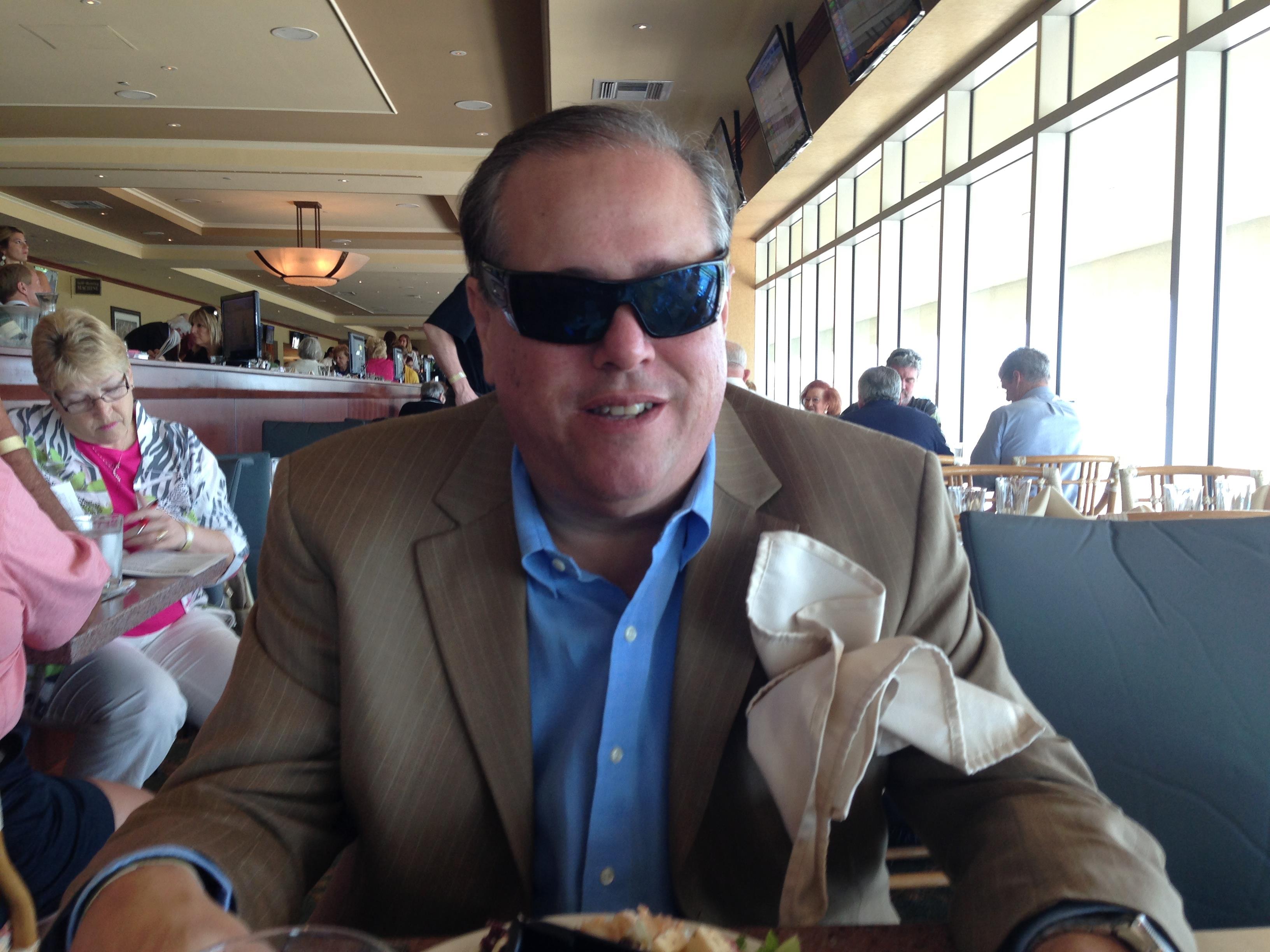 A man wearing sunglasses sitting at a table