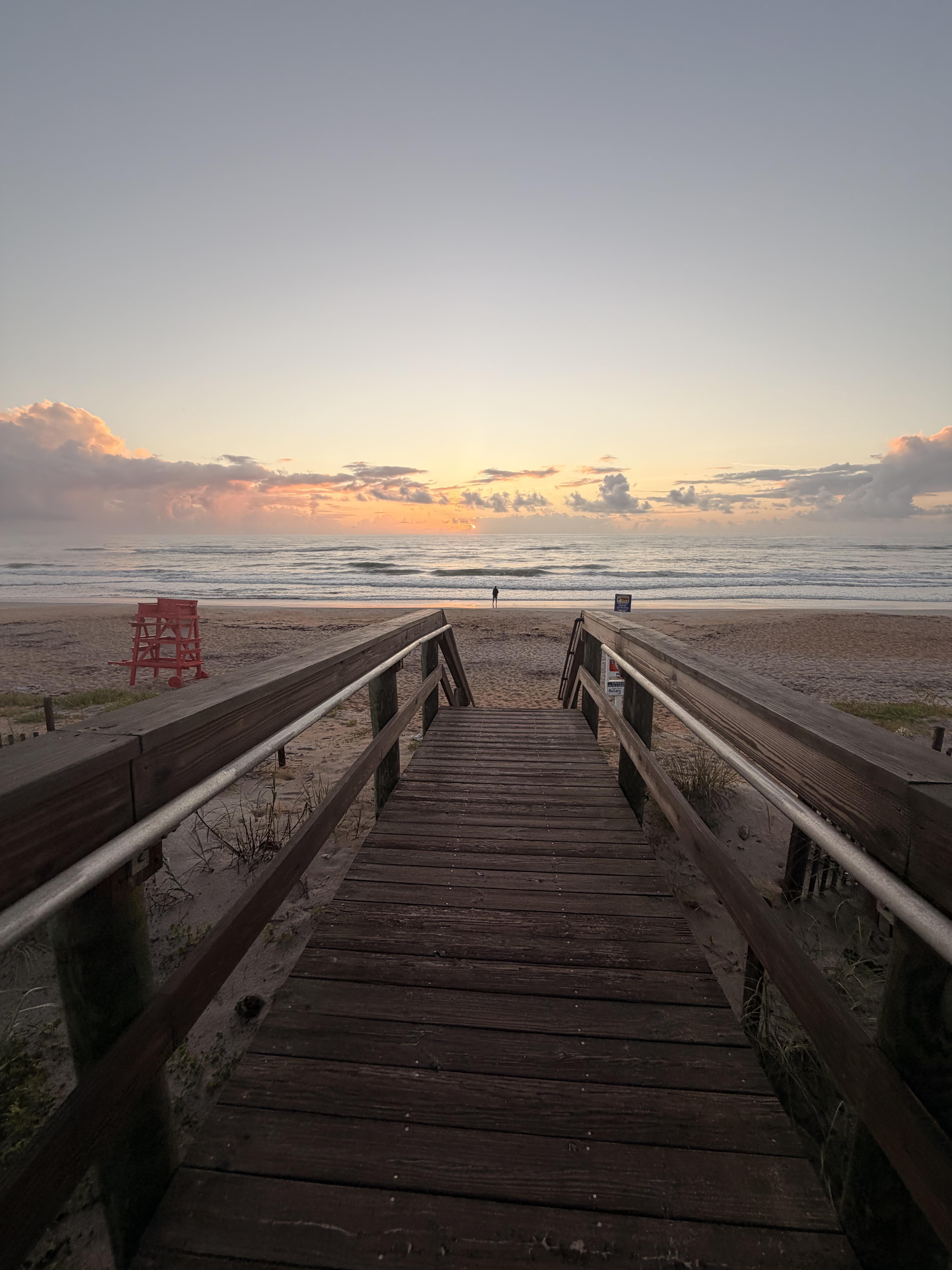 A wooden walkway leading to a beach