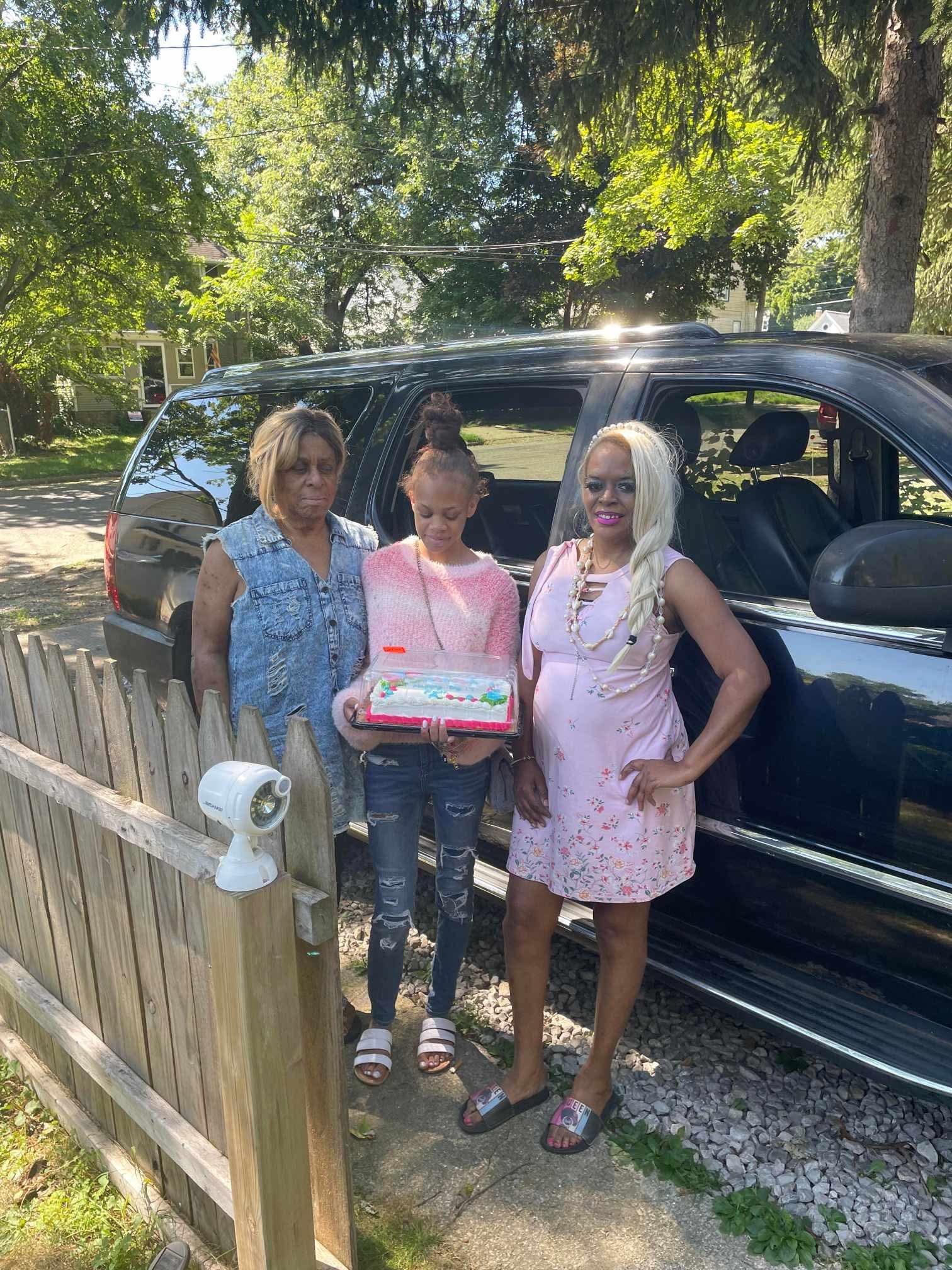 A group of women standing in front of a car