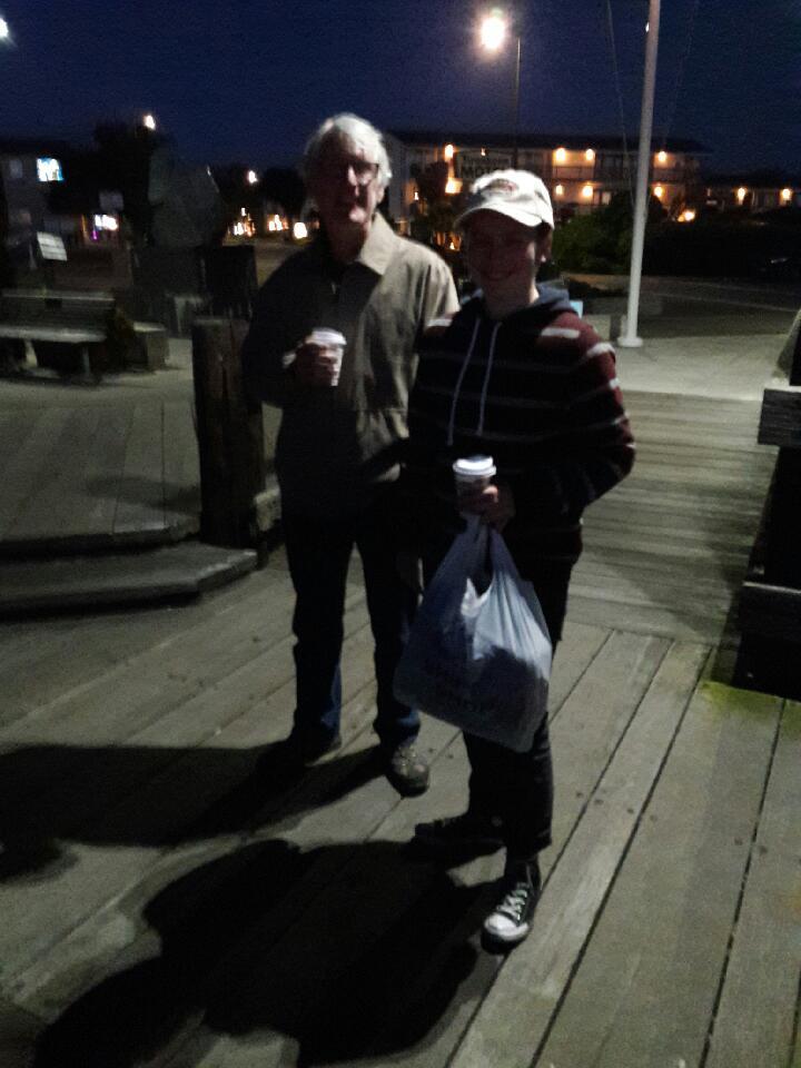 A man and woman standing on a wooden deck