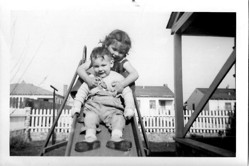 A girl holding a baby on a slide