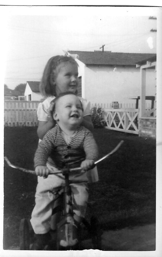 A girl riding a bicycle with a baby