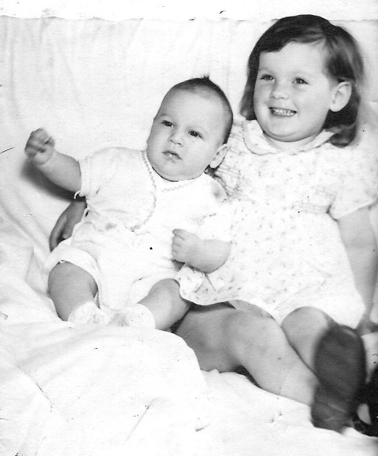A black and white photo of two babies
